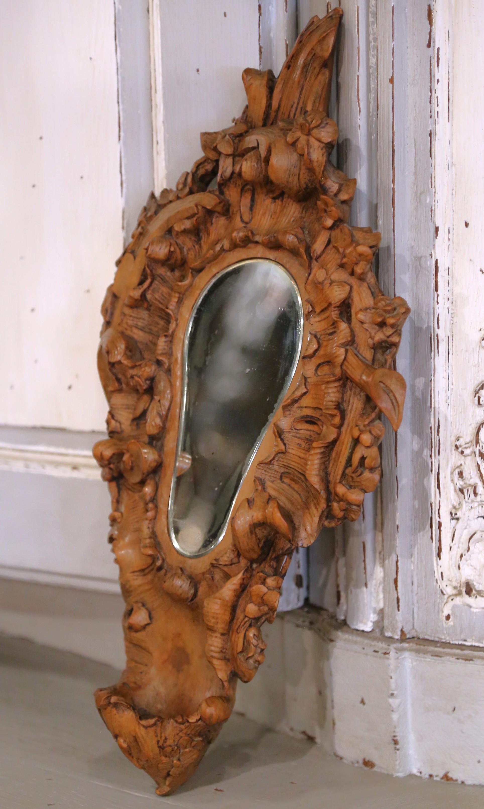 Carved in France circa 1870, this richly detailed wall mirror is a fine example of Black Forest-style craftsmanship, distinguished by its deeply sculptural forms and organic naturalism. Made from solid walnut, the frame is hand-carved in high relief