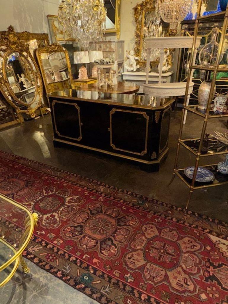 La credenza tradizionale francese del XIX secolo laccata nera con dettagli in bronzo dorato emana eleganza e charme grazie al suo stile tradizionale e alla finitura laccata. Questa credenza è stata progettata per portare un tocco di estetica