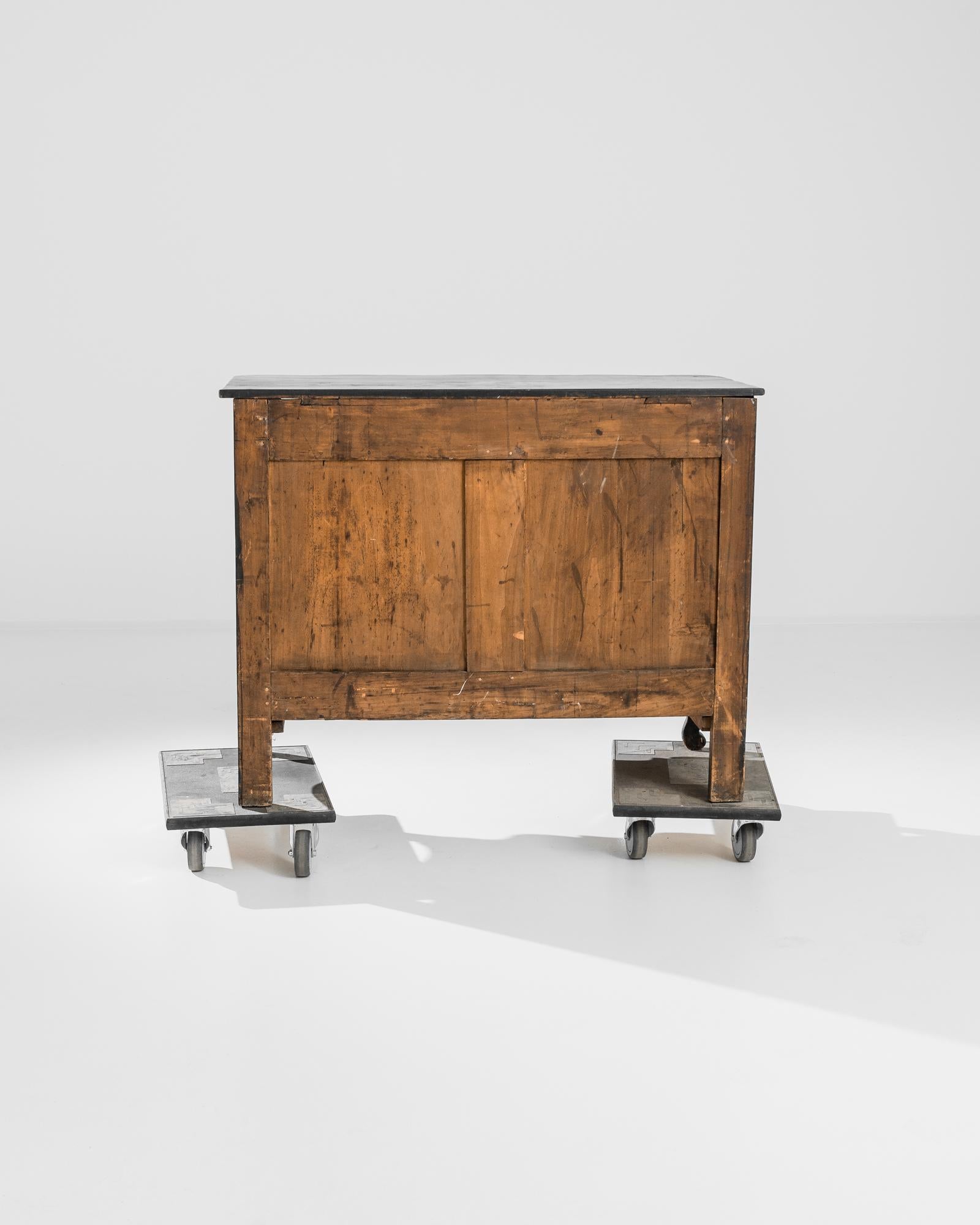 This antique French wooden chest was crafted in France, circa 1850. A scalloped chest rests on cabriole front feet, complimented by a carved scalloped apron. Gilded lock pieces and drawer handles in the shape of curved foliage gleam against the