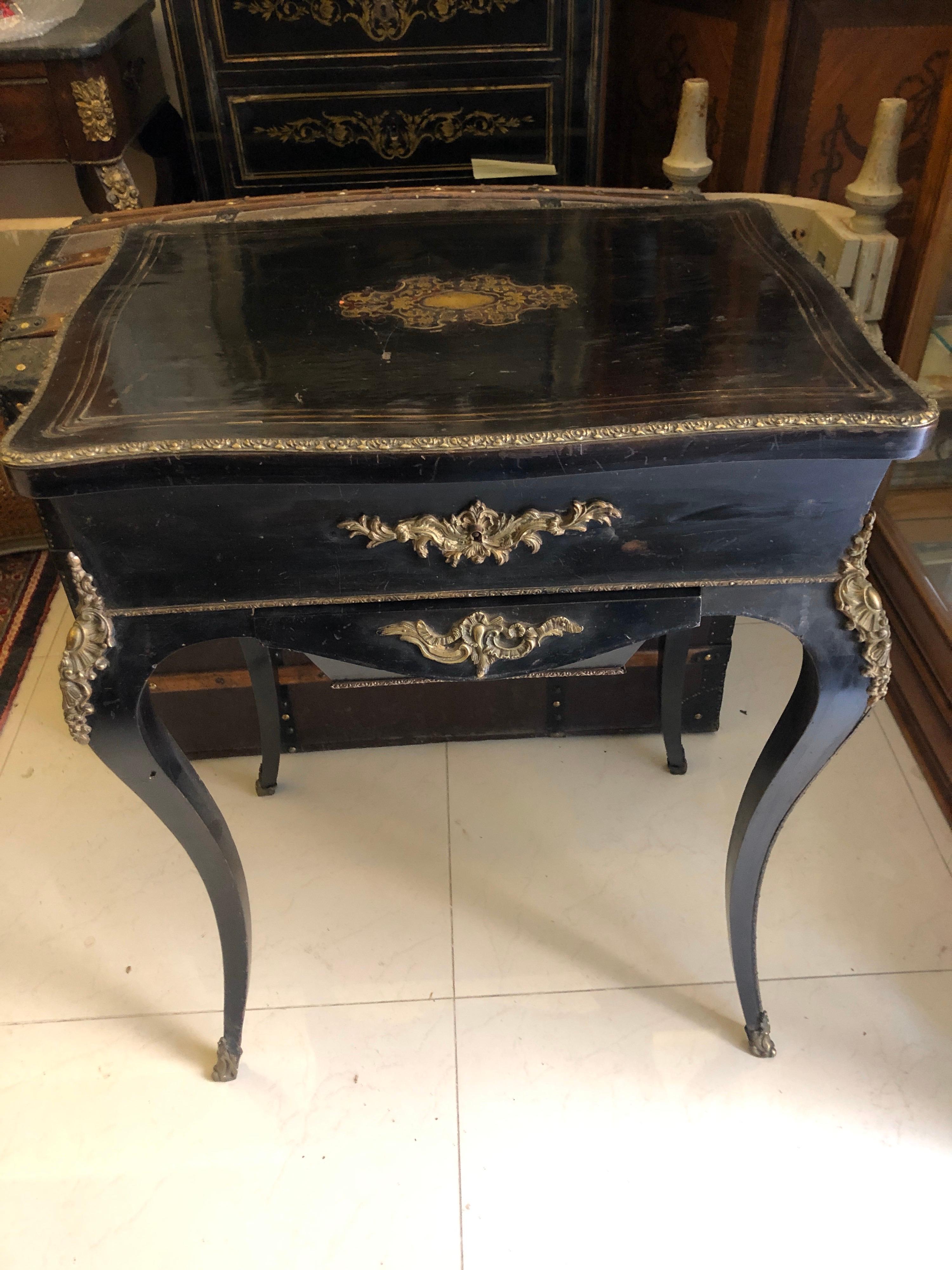 19th century work table in blackened wood inlaid with brass fillet, the lid reveals a tray with three compartments and a niche, it opens with a belt pocket. Curved legs, trim
brass and original mirror in very good condition. Very elegant piece