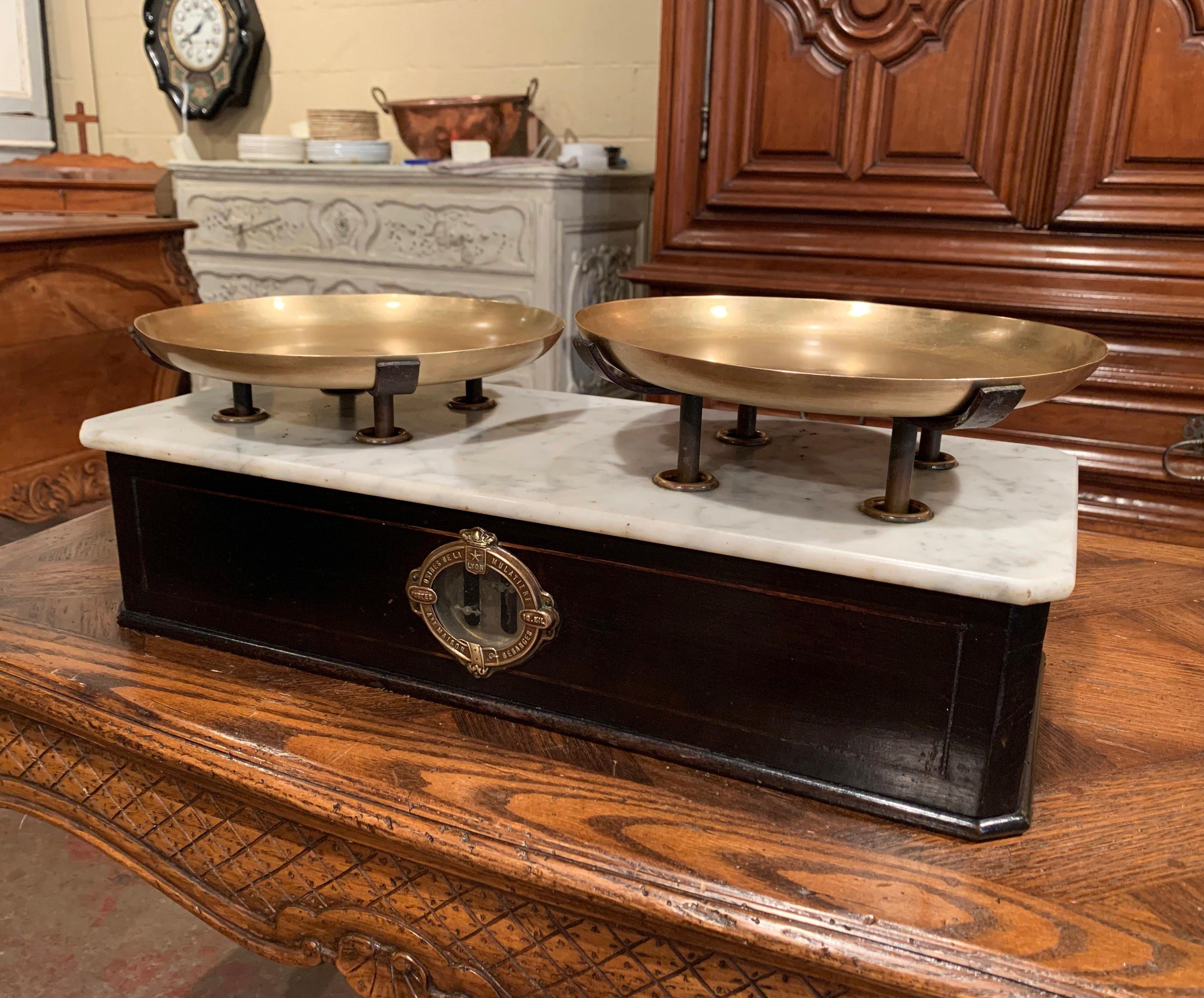 This Classic, antique fruitwood 10 kgs scale was created in France, circa 1870. The balance features some marquetry decor and the original brass plateaus over the white marble top. The scale is in excellent working order with a rich blackened finish