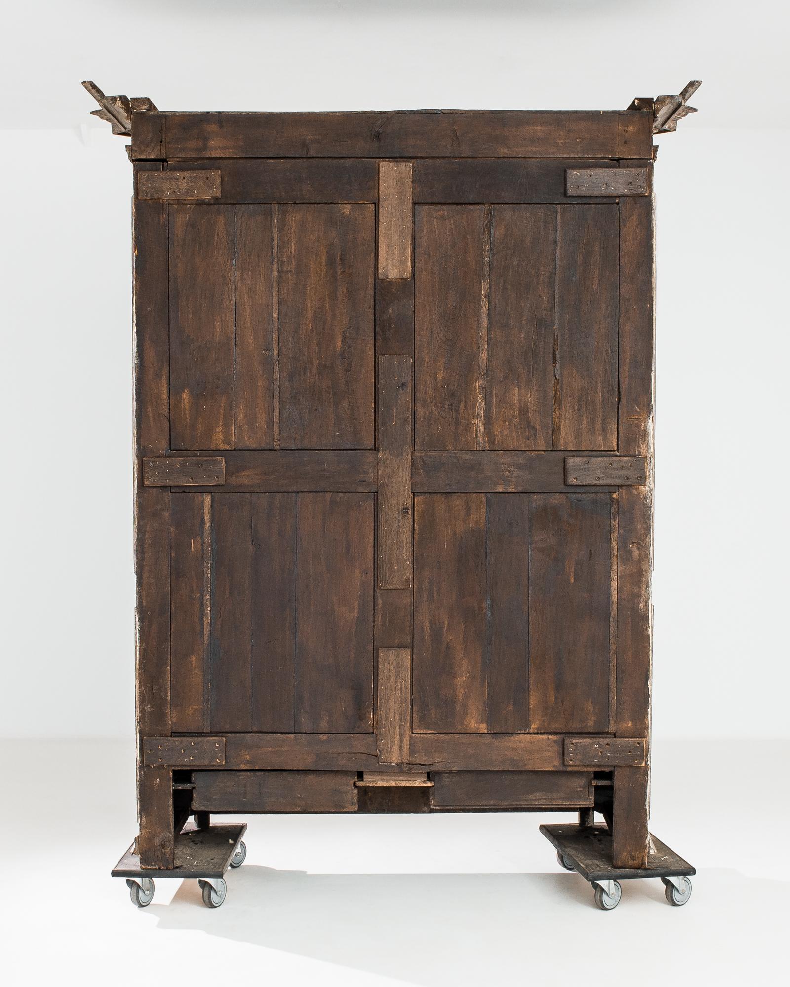 This French oak armoire, made circa 1860, imparts the distinguished air of classical antiquity. The cabinet adopts an upright shape accentuated by the mitered corners of the molded cornice. Simple elegant outlines of the carvings on the raised doors