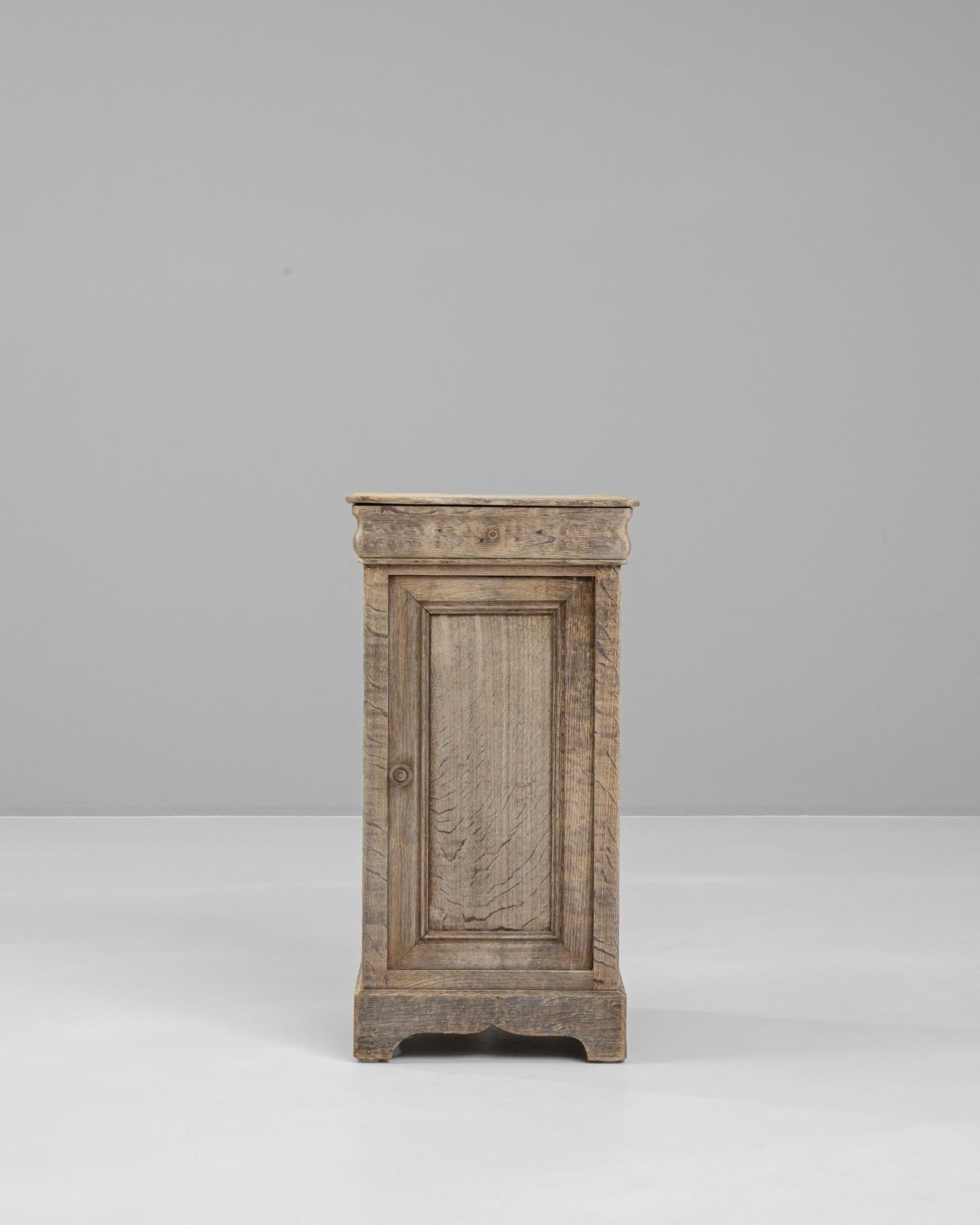 Enhance your bedroom with the timeless charm of this 19th Century French Bleached Oak Bedside Table. Crafted from solid oak, this piece has been expertly bleached to highlight the natural grain and unique character of the wood. An authentic antique