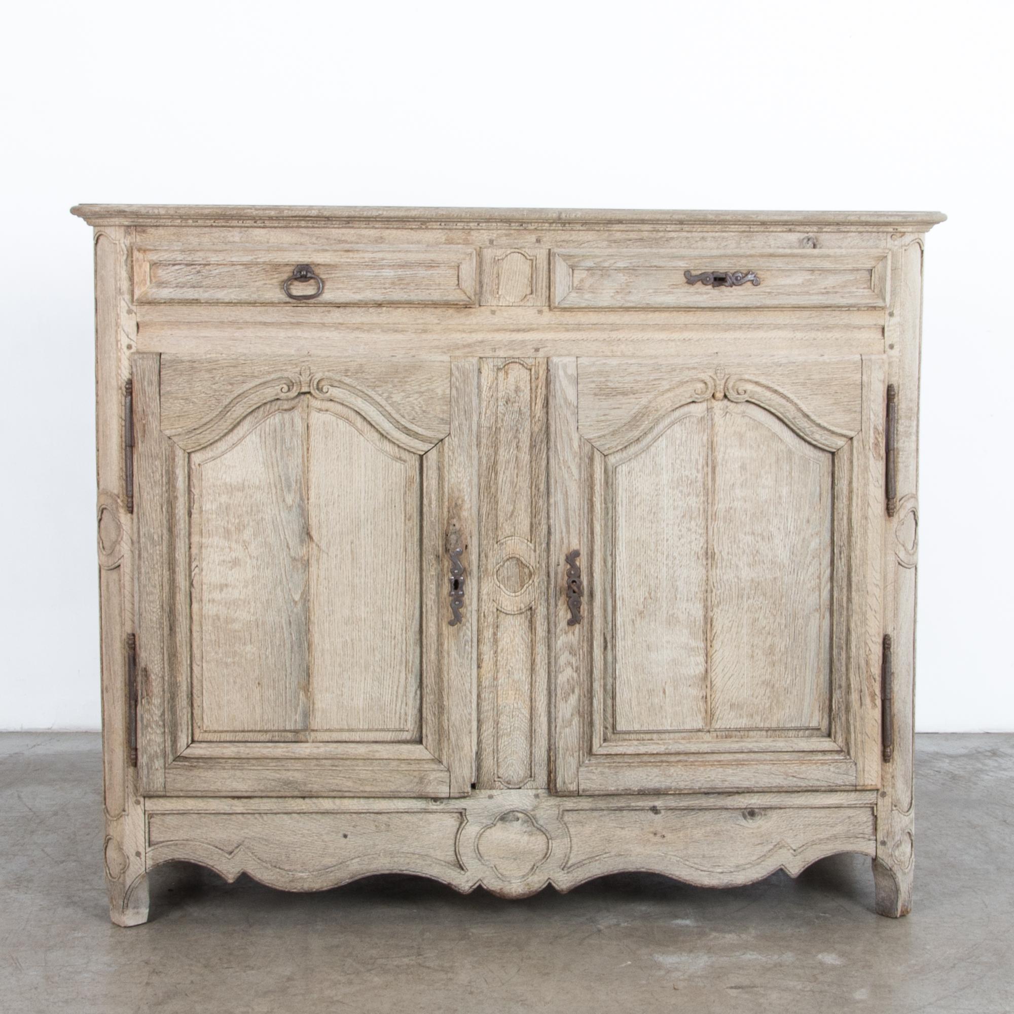 A two door and drawer cabinet from France, circa 1800. Representing the casual yet refined aesthetic of the French countryside, finished in a contemporary bright finish, enhancing the natural textured figure of the wood and subtle carved ornament. A