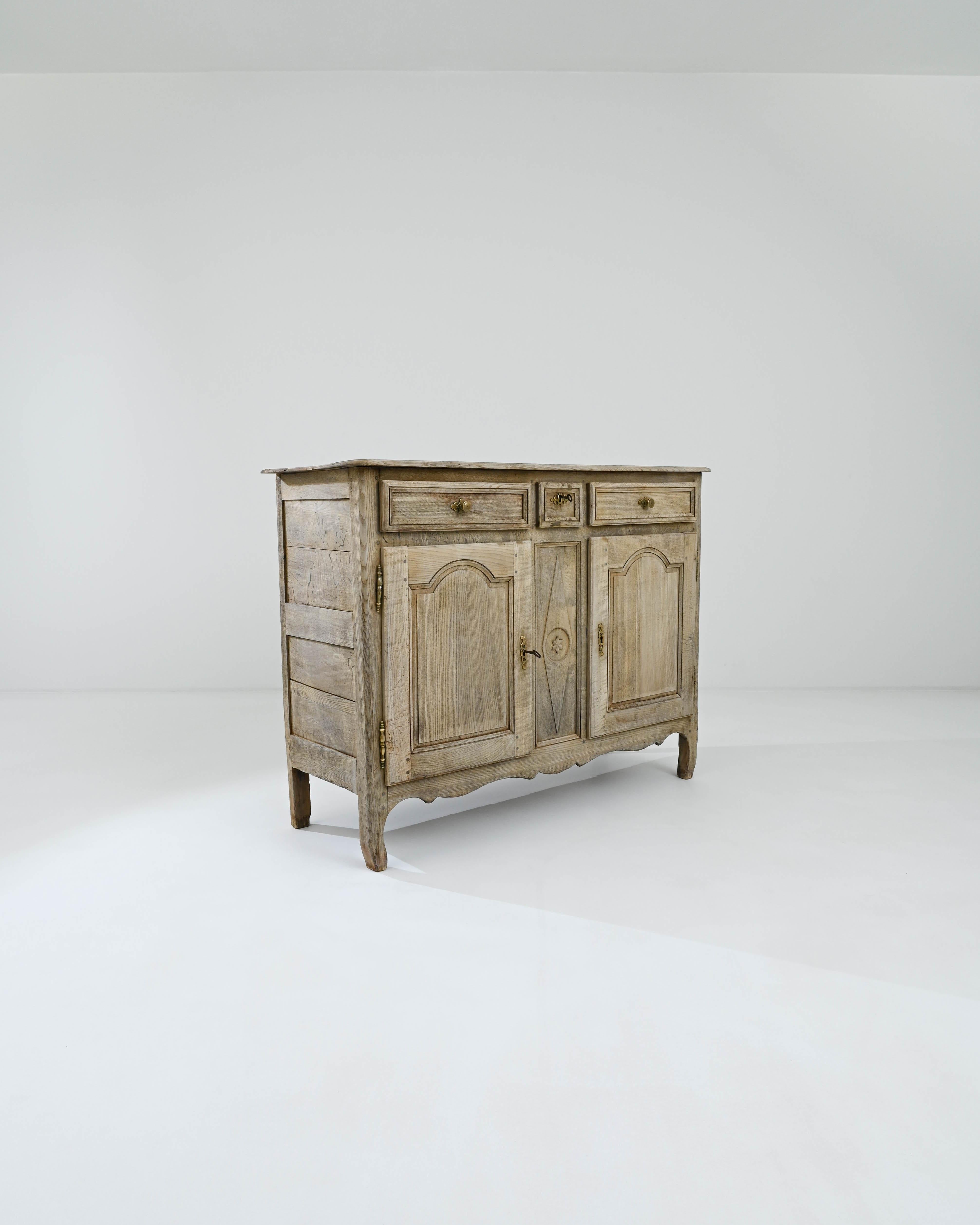 The quintessential Country French buffet cabinet, made in the 19th Century. The simple geometric shape recalls a countryside local and the time tested approach of regional French cabinet makers. Combining earthy colors and elevated craftsmanship,