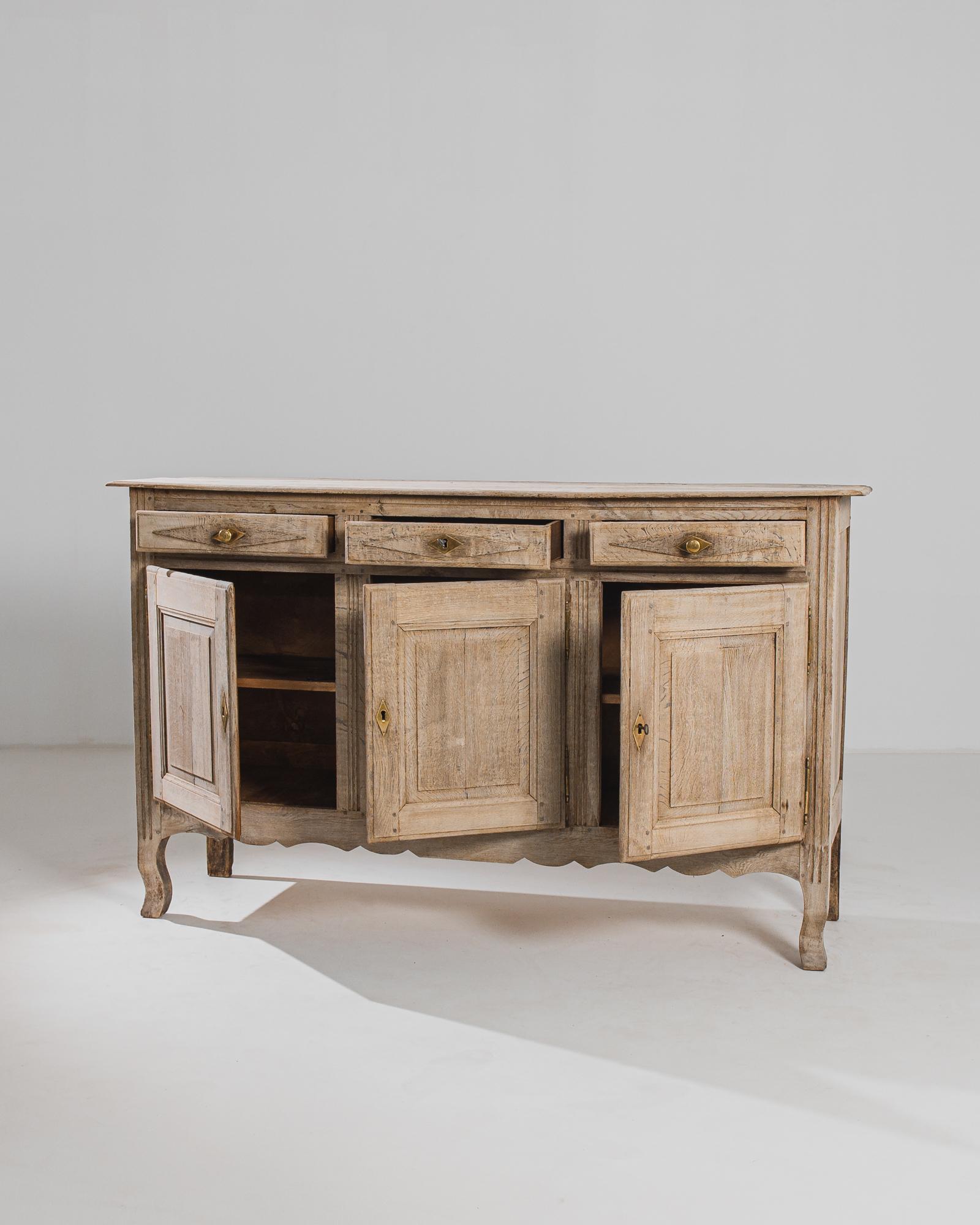 Stepping out of the elegance of 19th-century France, this bleached oak buffet embodies the timeless charm and sophistication of French design. Crafted with meticulous attention to detail, this piece showcases the exquisite beauty of natural oak