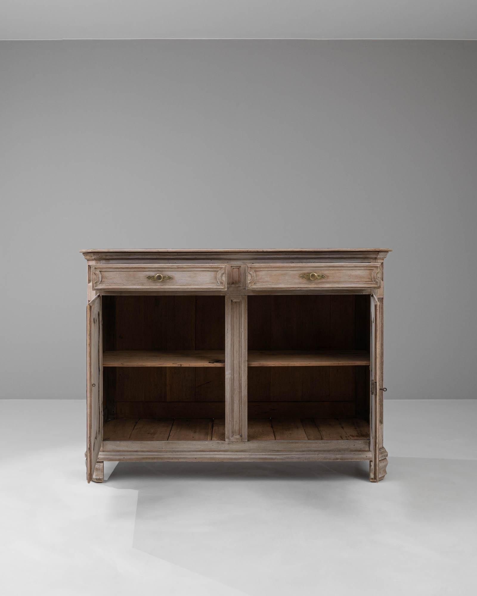 Step back into the romantic elegance of the 19th century with this stunning French bleached oak buffet. Meticulously crafted from rich oak, this piece has been carefully bleached to achieve a soft, weathered patina that highlights the intricate