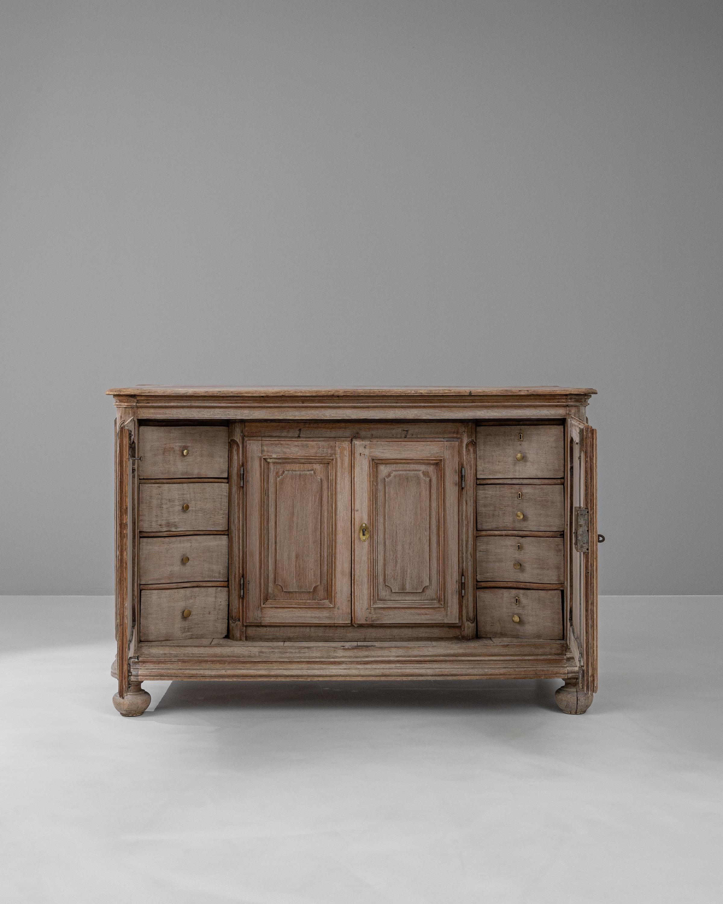 This 19th-century French bleached oak buffet is an exemplar of fine craftsmanship and timeless style, offering both beauty and functionality for any home. Its gently washed finish brings a light, airy feel to the solid oak construction, highlighting