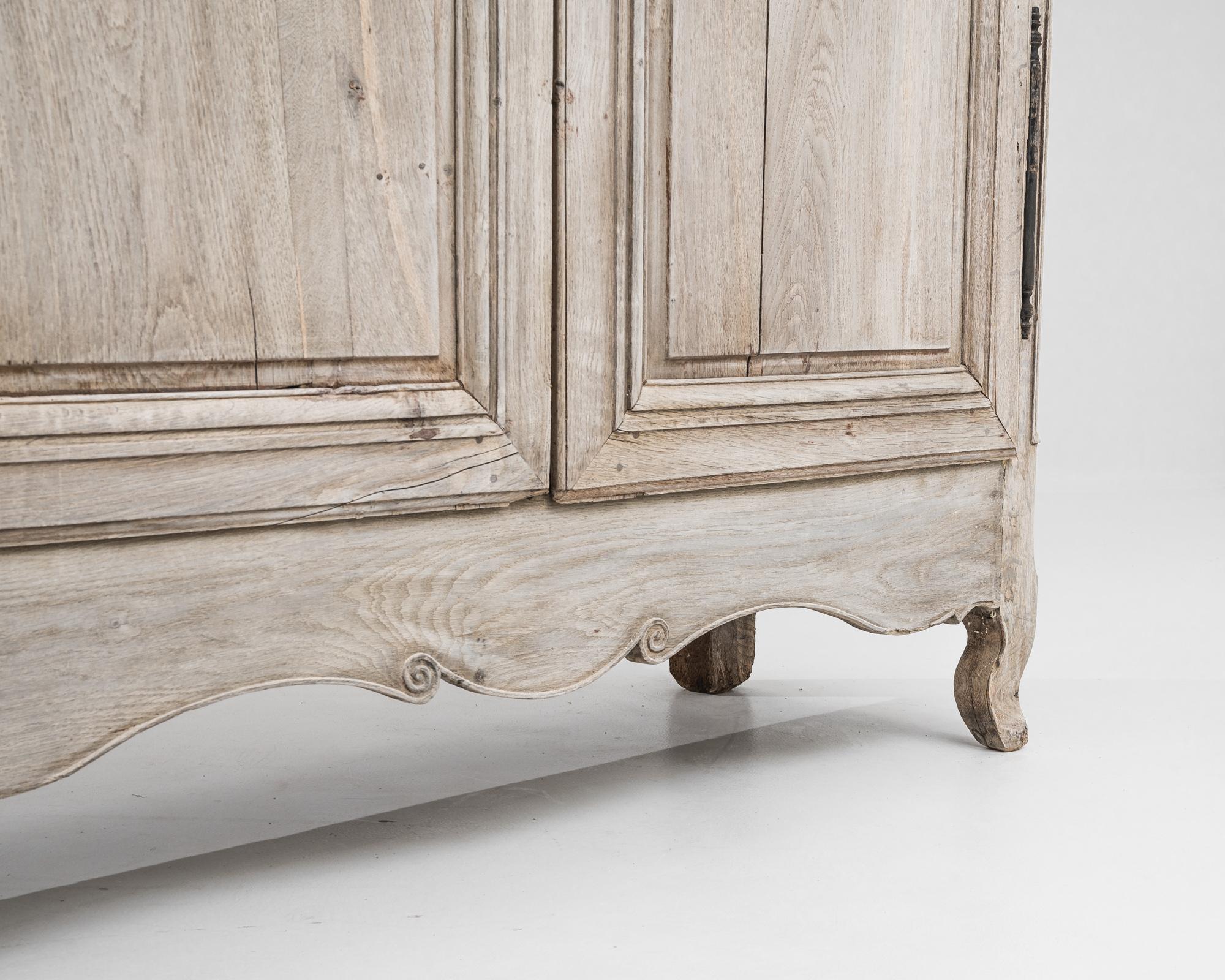 Dieser französische Holzschrank aus dem frühen 19. Jahrhundert ist von beeindruckender Größe und verbindet antiken Charme mit unvergleichlicher Handwerkskunst. Durch ein behutsames Bleichverfahren wird die Oberfläche des Eichenholzes verjüngt,