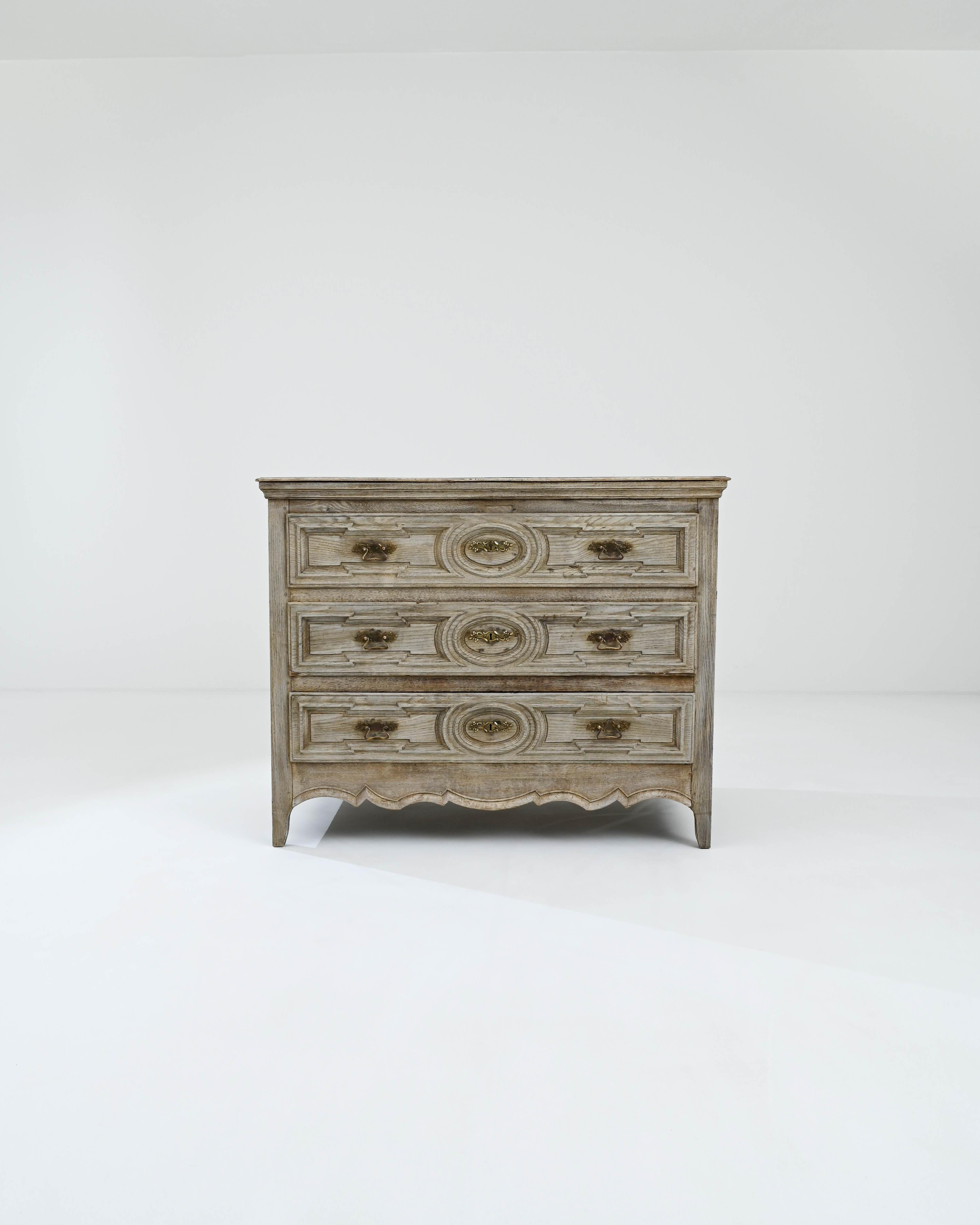 A wooden chest of drawers created in 19th century France. Composed with a dignified aura, this classically beautiful set of drawers radiates calm, elegance, and thoughtful design. Elaborately sculpted drawer fronts and artfully sculpted aprons,