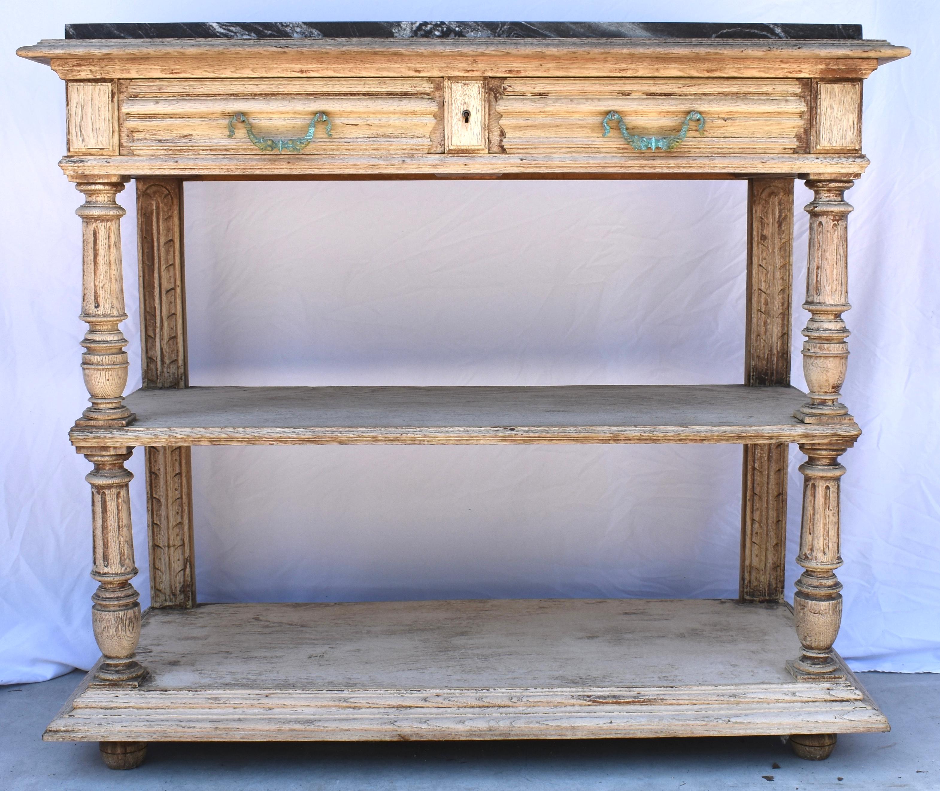 Built in France in the late 1800s using oak this sideboard is topped by black marble (replaced) and is absolutely gorgeous. The sideboard features two shelves, the bottom one framed by tapered molding and sitting on bun feet. The middle shelf shows