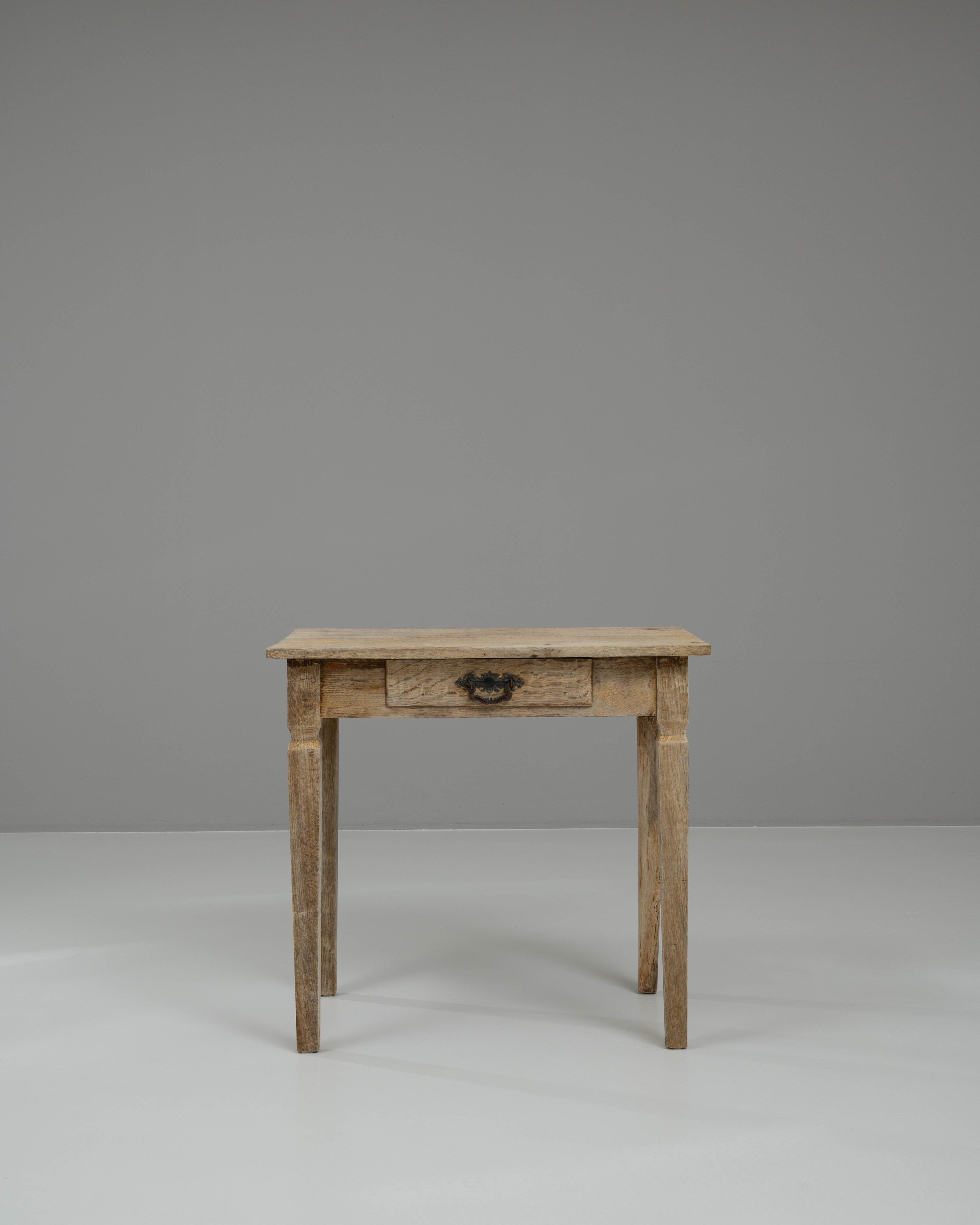 Ajoutez une touche d'élégance rustique à votre intérieur avec cette charmante table d'appoint en chêne blanchi français du XIXe siècle. Fabriquée de manière experte en chêne massif, cette table présente une magnifique finition blanchie qui met en