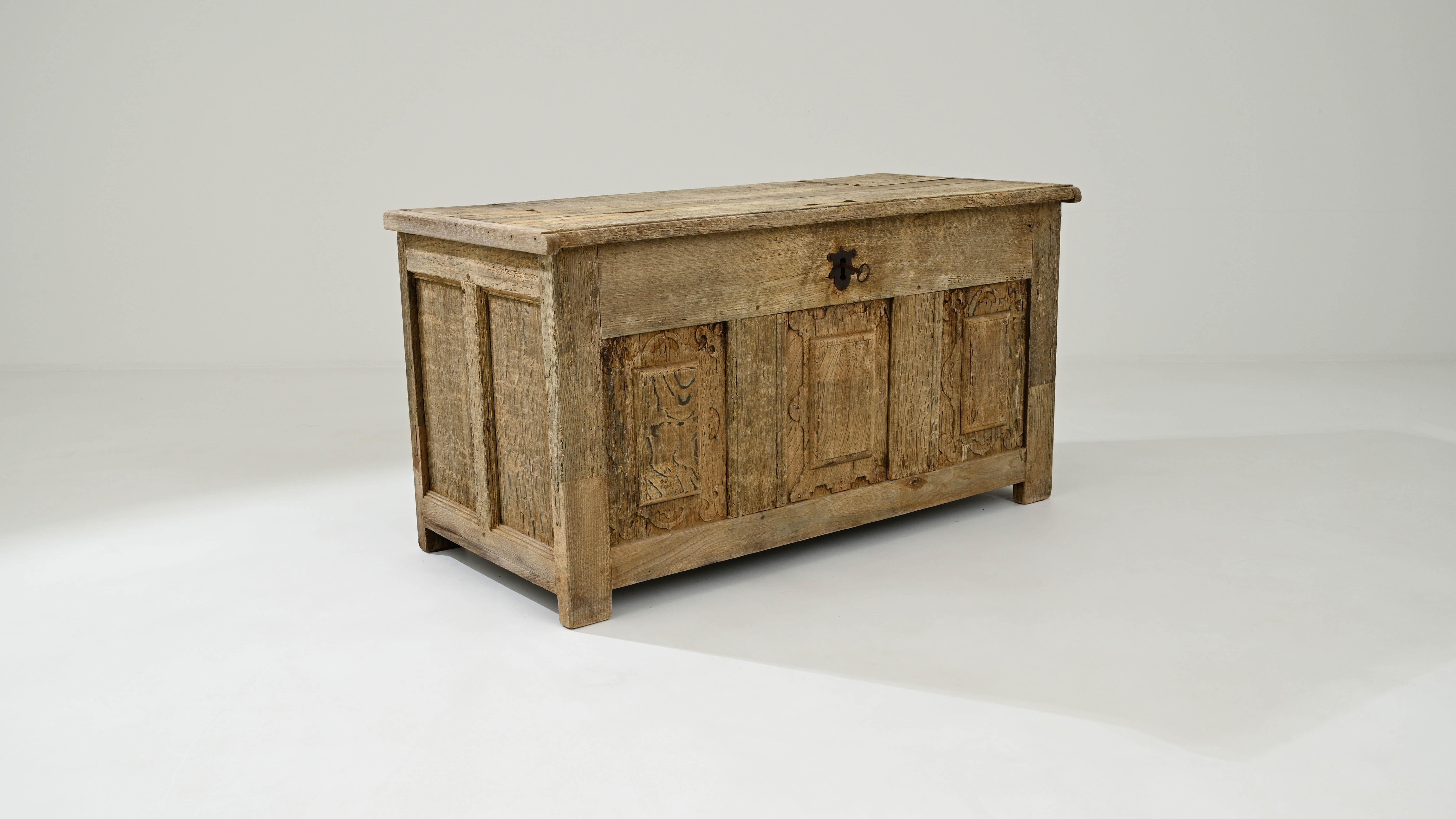 A beautiful bleached oak chest, from circa 19th Century France. Refined in its old age, this antique yet stylish chest offers a roomy storage compartment and a charming exterior. Sparse metal details and finely carved details ripple across its