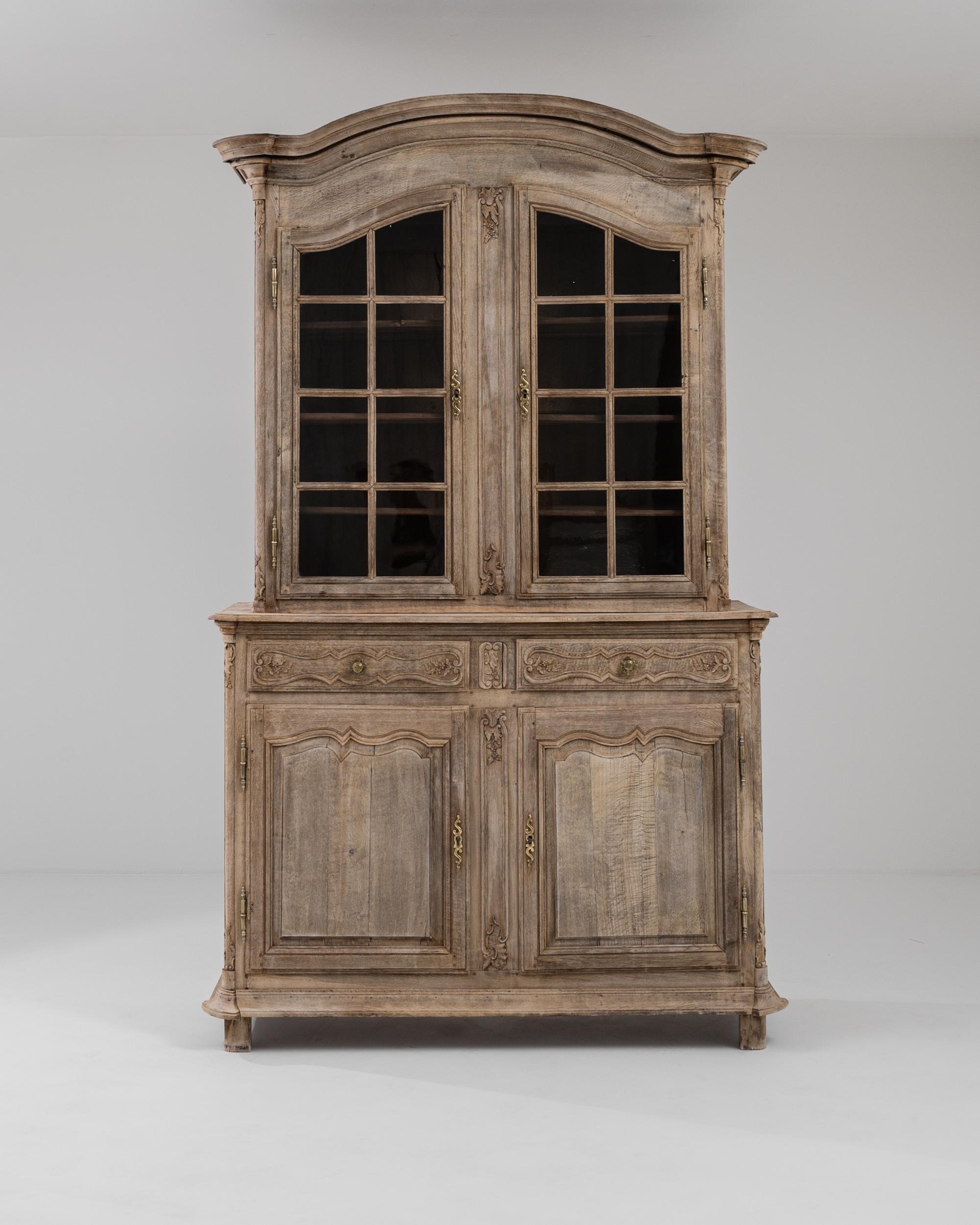 A wooden vitrine made in 19th century, France. This hulking display cabinet features two lower doors and two drawers, the glazed cabinet above houses four shelves. Providing a wealth of storage and an undeniable charm, this vitrine brings a unique
