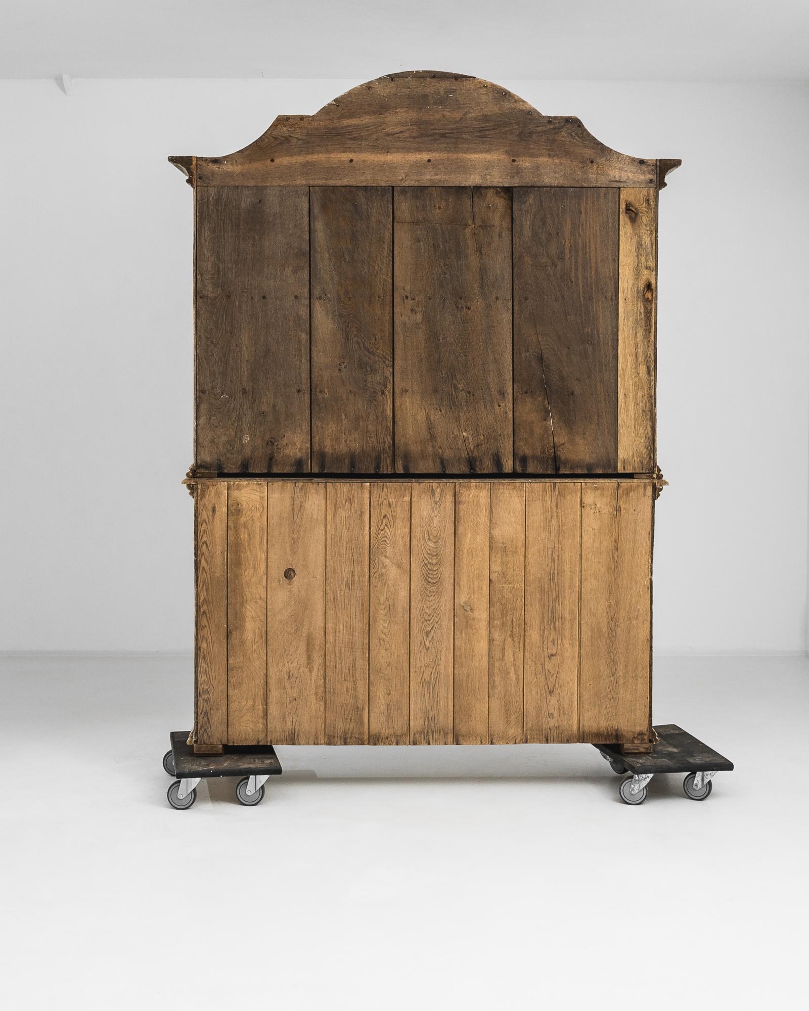 Impressive in stature, this antique oak vitrine is built elegantly in design. Built in France in the early 1800s, this vitrine is beautifully designed from its sumptuously shaped construction and ornate detail, this shows the true craftmanship that