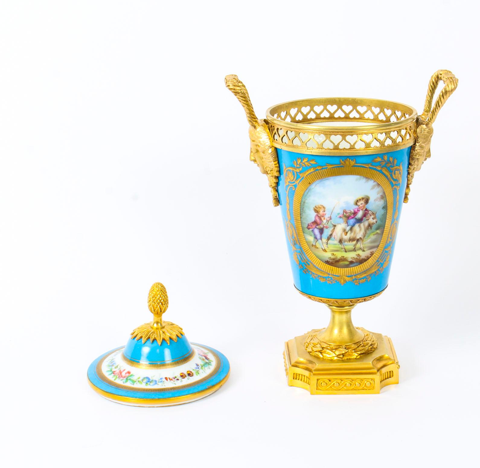 This is a beautiful antique French Sevres porcelain and ormolu-mounted garniture vase and cover, in Louis XV style, circa 1880 in date.

Superbly decorated in Sevres Bleu Celeste with ovals of a hand painted floral bouquet and children playing