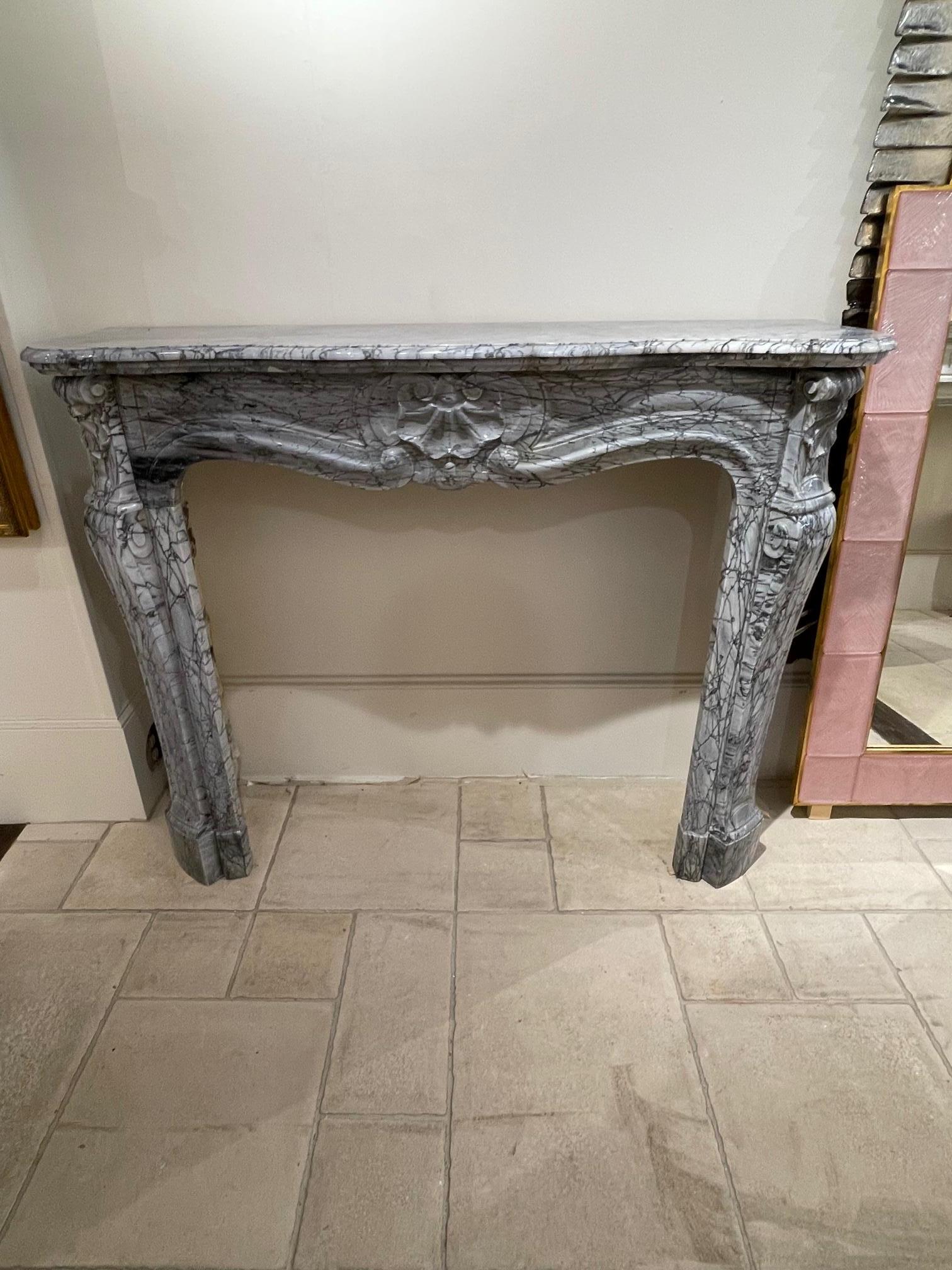 Extraordinary 19th century French Bleu Turquin Louis XV style carved marble mantel. Decorative carvings and exceptional veining on this piece. A true work of art that provides an extremely elegant touch!