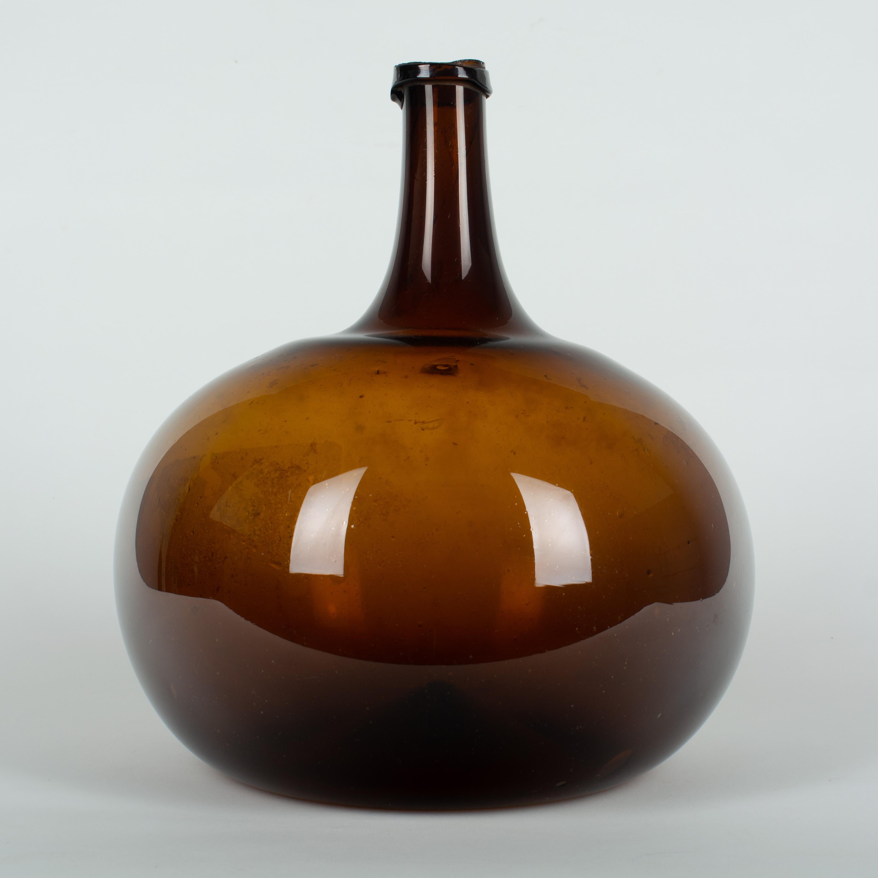A 19th century French globular form amber demijohn bottle with air bubbles typical of hand blown glass. Please refer to photos for more details.