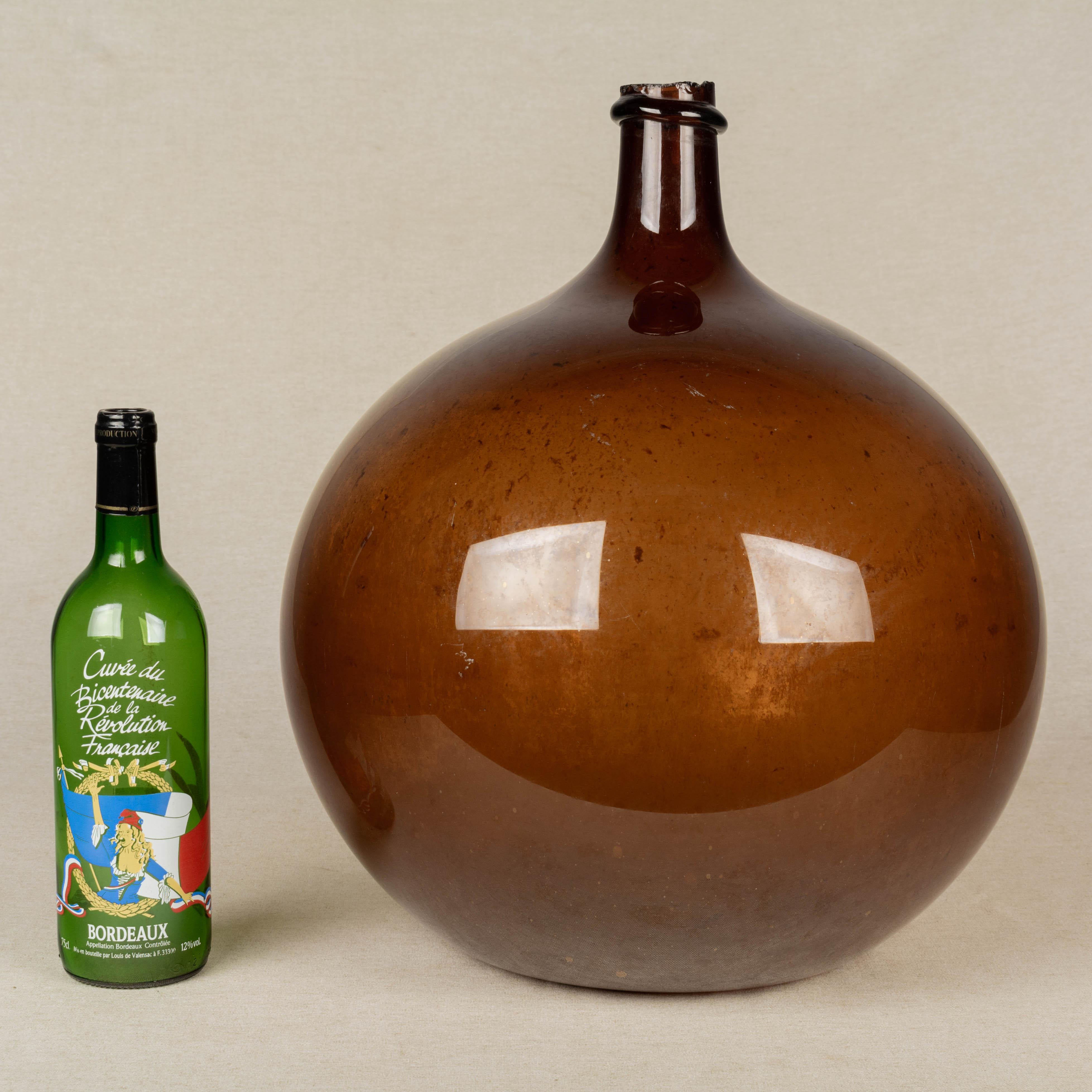 A 19th century French globular form amber demijohn bottle with air bubbles typical of handblown glass. Please refer to photos for more details. 
Measures: 18
