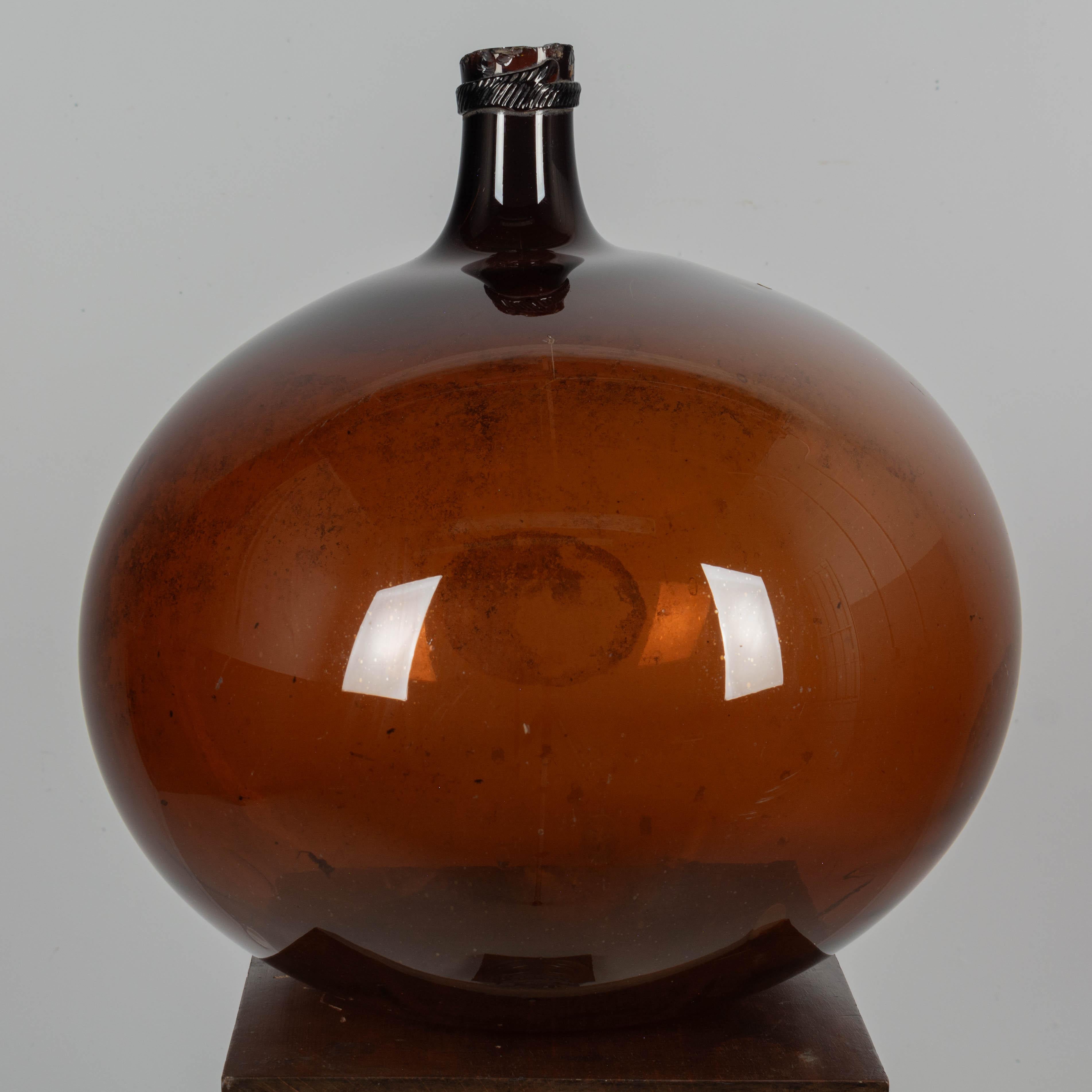 A large 19th century French globular form amber demijohn bottle with air bubbles typical of handblown glass. Circa 1850-1860
Dimensions: 18
