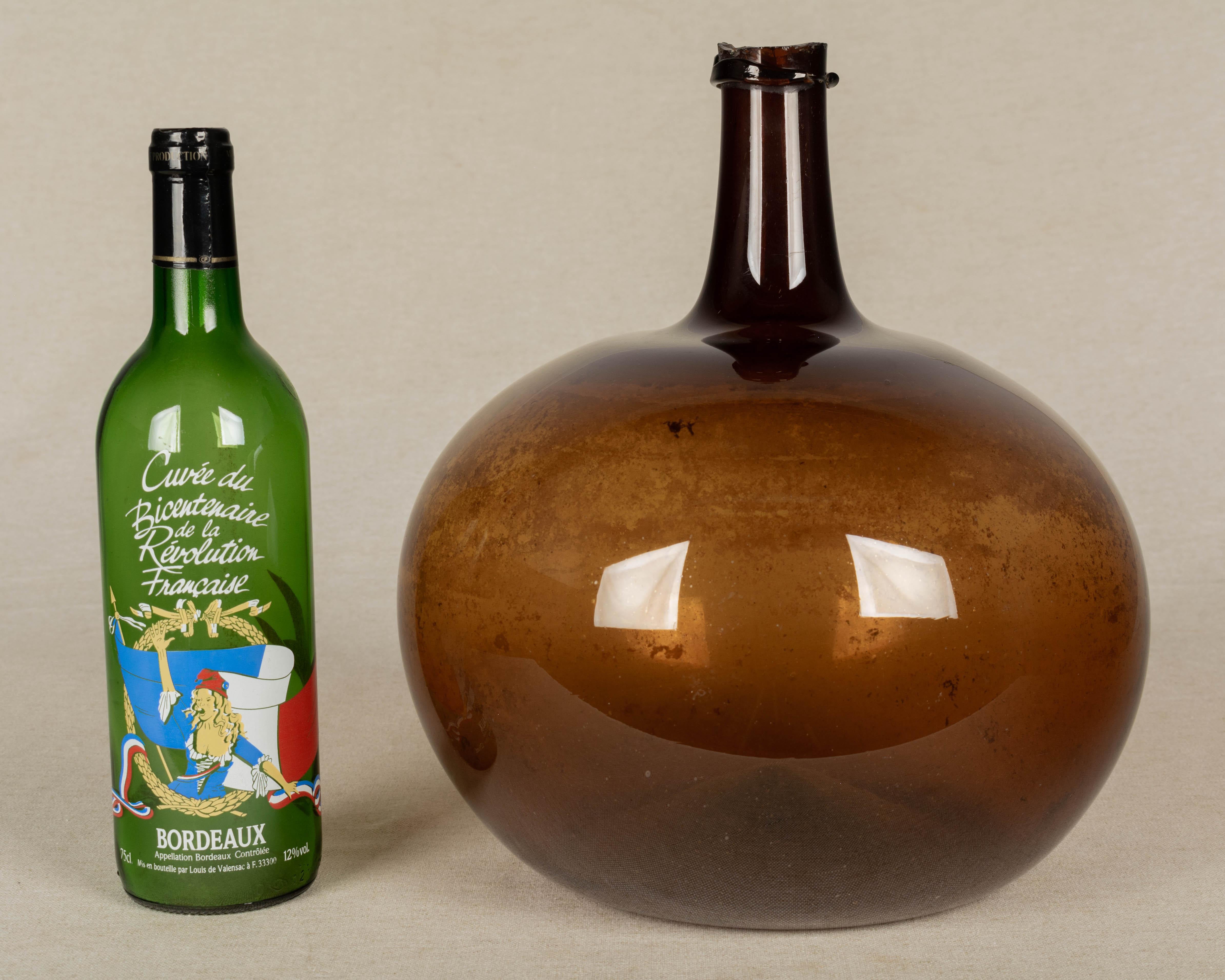 A 19th century French globular form amber demijohn bottle with air bubbles typical of handblown glass. Please refer to photos for more details. 
12