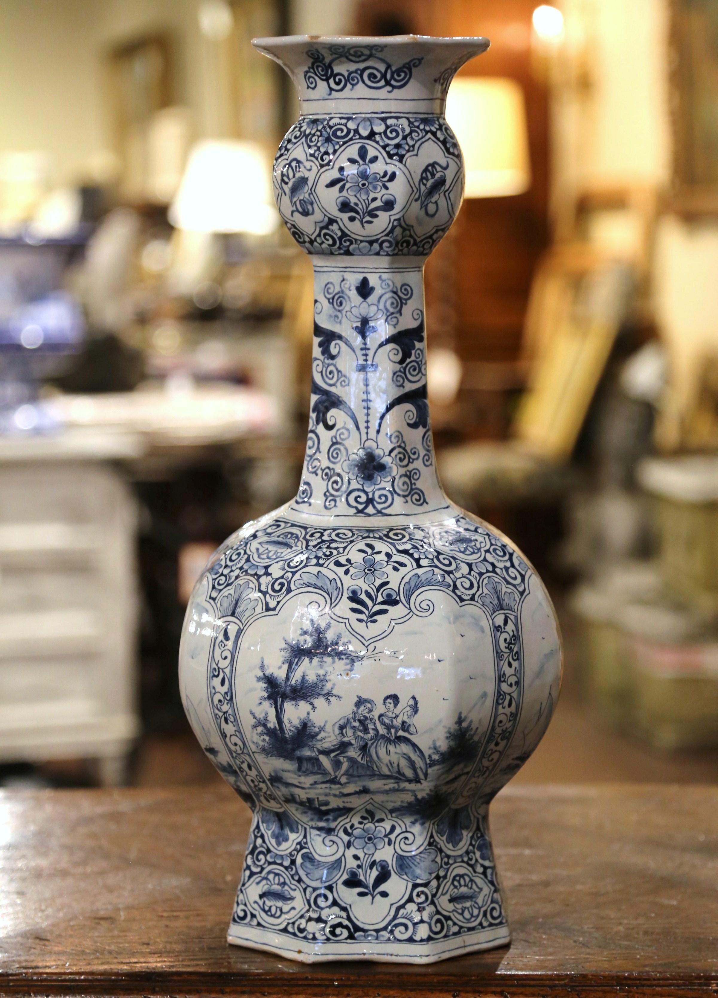 Decorate a console or buffet with this elegant antique vase. Crafted in France, circa 1880, the tall faience vase is beautifully shaped with a rounded body and a long, thin neck. Hand painted in the traditional blue and white palette, the sculpted
