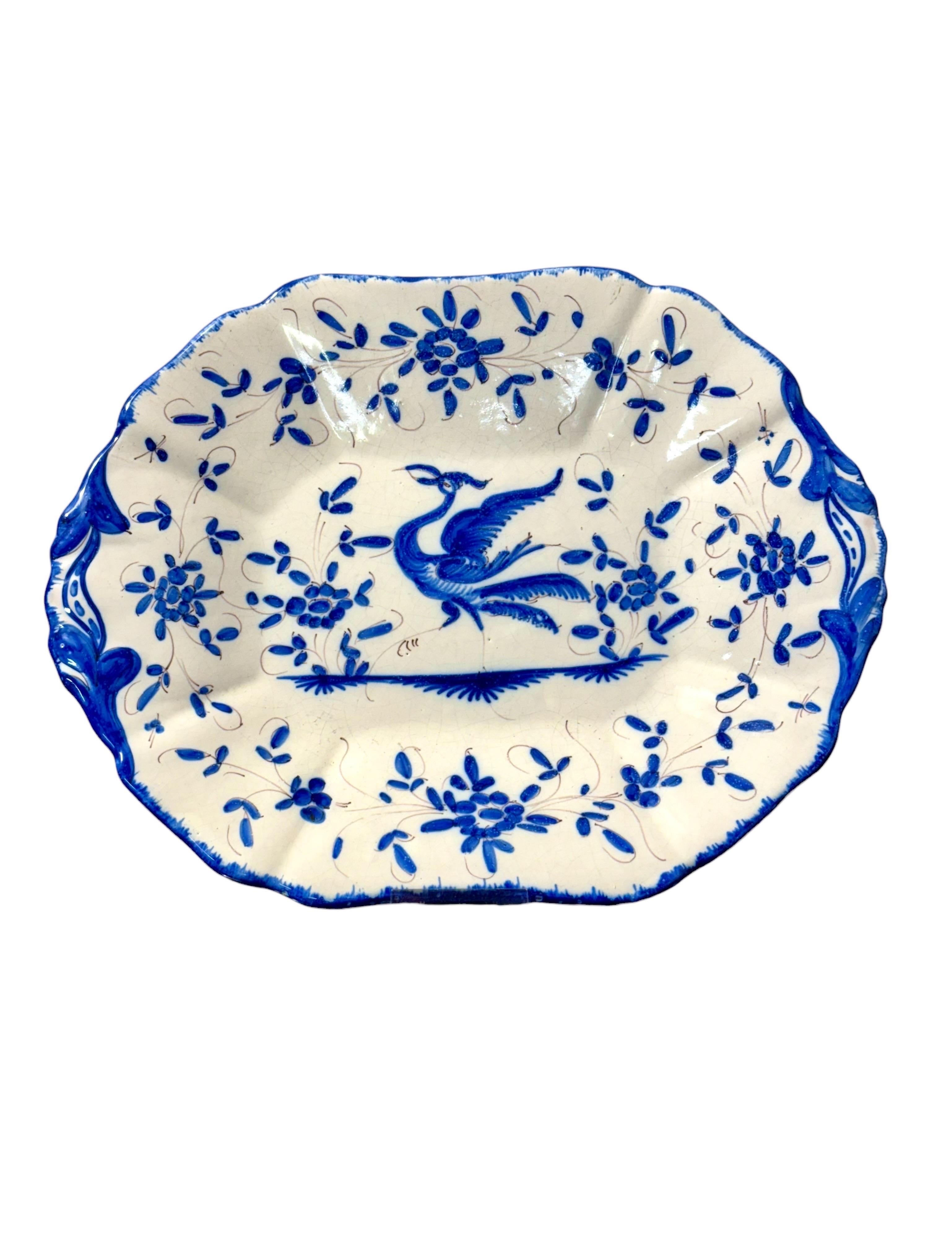 Cette magnifique soupière en faïence française du XIXe siècle et son sous-plat assorti sont un exemple frappant de faïence traditionnelle bleu et blanc, entièrement peinte à la main et pleine de caractère. L'ensemble présente une palette vivante de