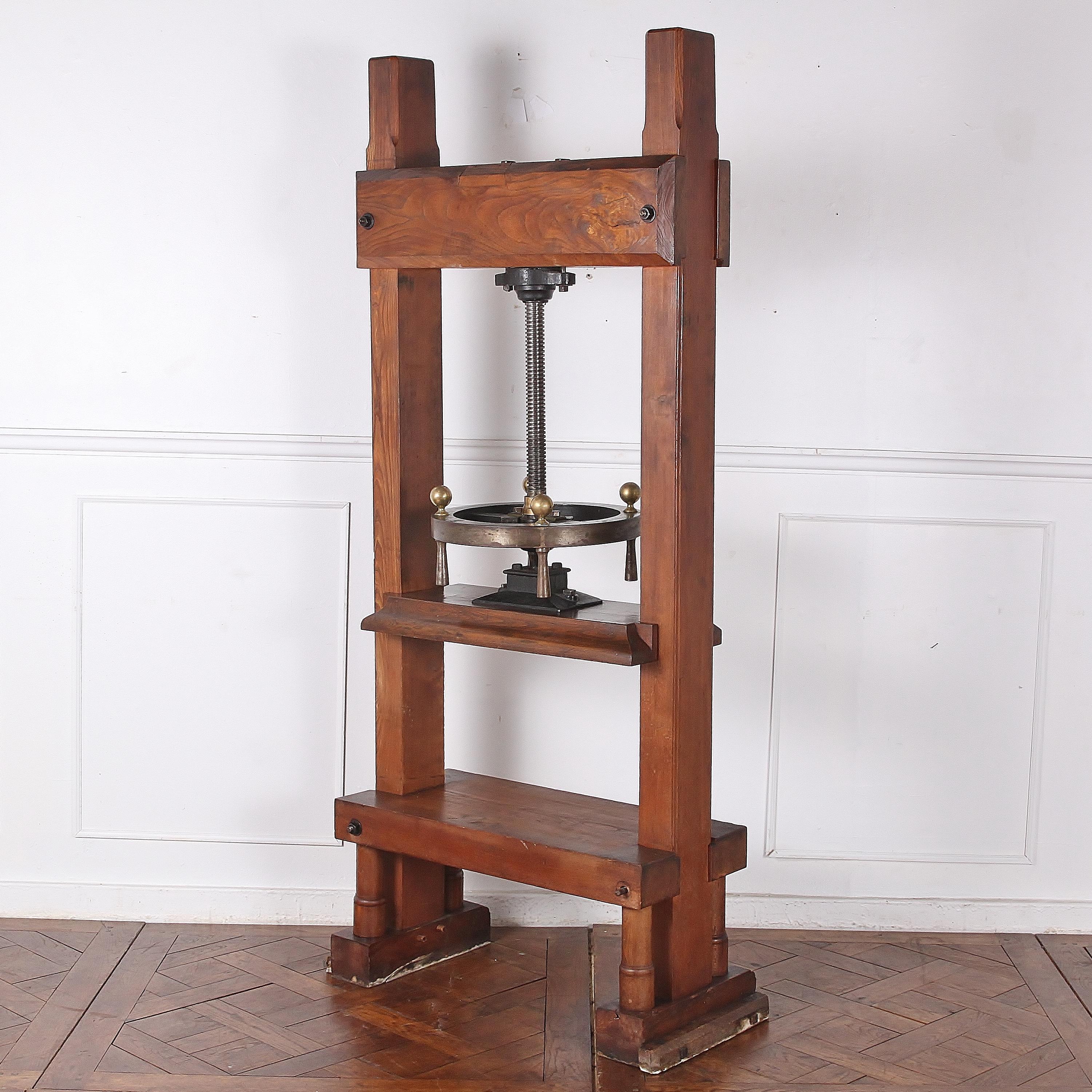 A 19th century French book press, the heavy steel screw / press mechanism suspended within a stout chestnut-wood frame. The chestnut timber has some lovely figuring and a warm patina and the fully-functional mechanism has a sculptural quality to the