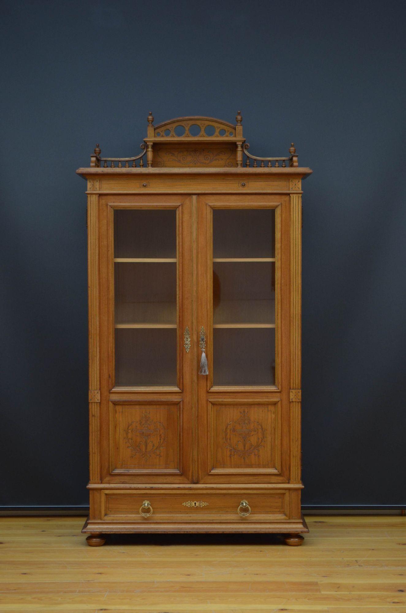 R013 Attractive 19th walnut vitrine, having shaped upstand on turned spindles to the back, a figured walnut top and pair of glazed doors with original working lock and a key, enclosing three height adjustable shelves, all flanked by reeded