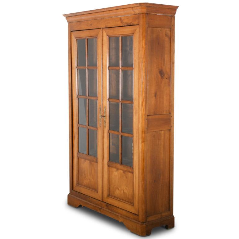 A late-19 century cherry bookcase, the two doors with eight glass panes and mullions, the interior having four adjustable shelves.
Solid cherry two-panel sides; nicely-detailed pierced brass escutcheon plates.
A simple well-proportioned piece with