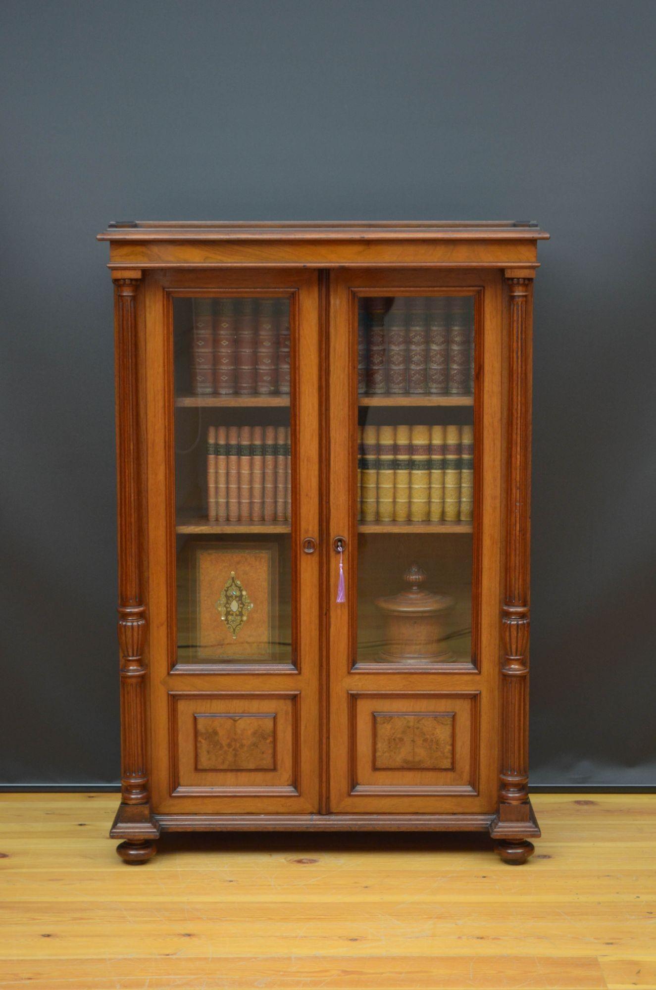 R021 attractive 19th century bookcase or display cabinet in walnut, having figured walnut top with a shaped gallery and moulded edge above a pair of glazed doors with burr walnut fielded panels to the base, fitted with original working lock and a