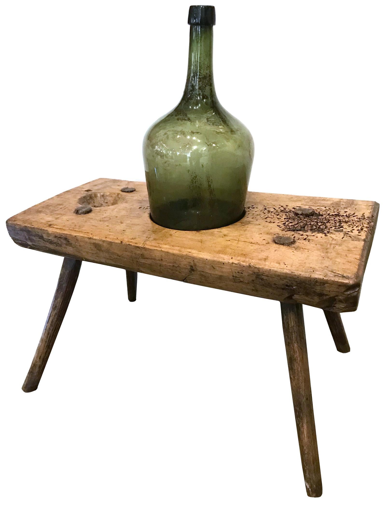 A 19th century French walnut bottle-corking bench, made for use in homes where small batches of home-made wine were harvested and bottled, with 19th century blown-glass decanter.