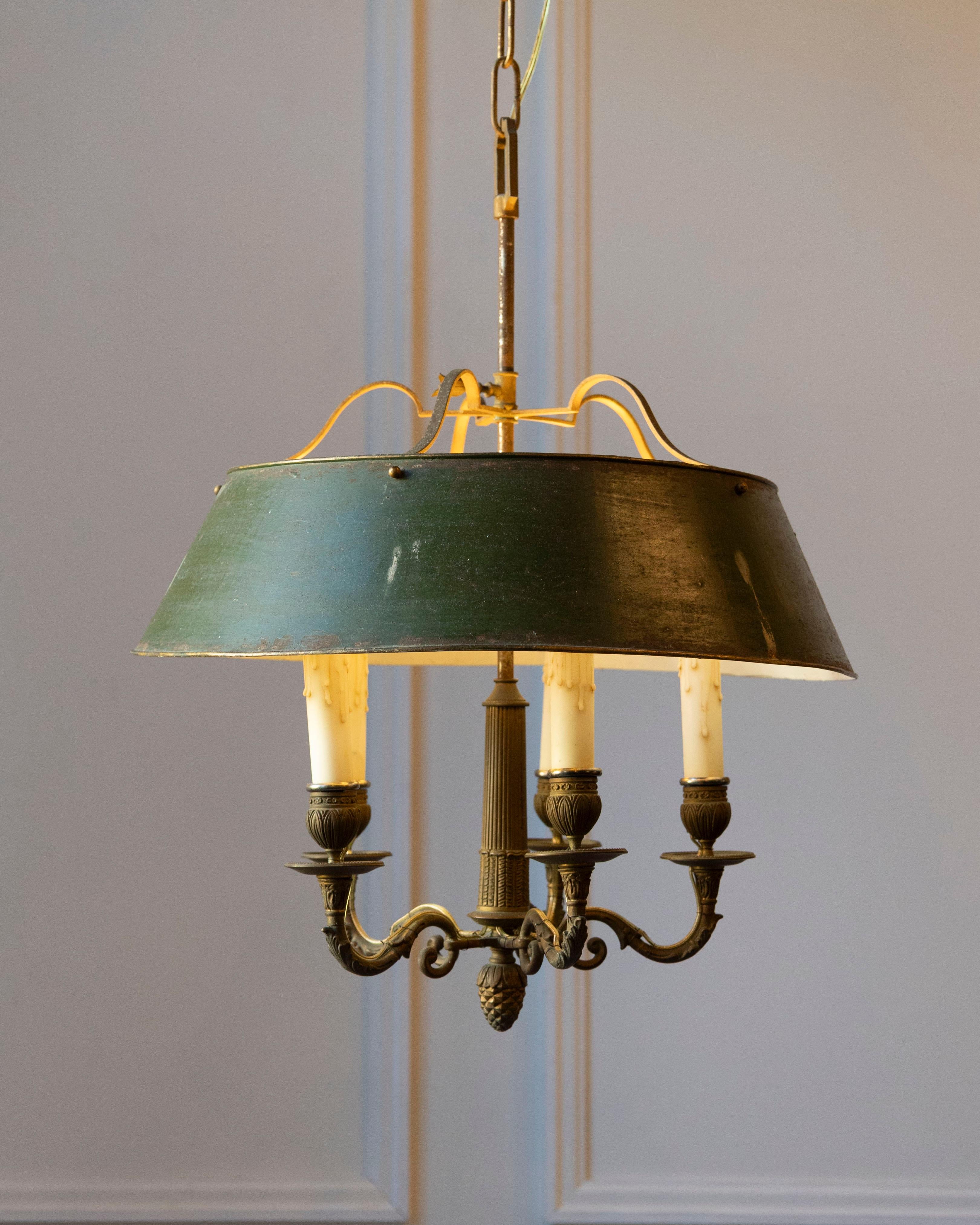 Un raffinato lampadario bouillotte francese del XIX secolo, realizzato in bronzo con il suo paralume originale in tole verde. Classico nella forma e splendidamente bilanciato, questo pezzo riflette la sobria eleganza del primo design francese