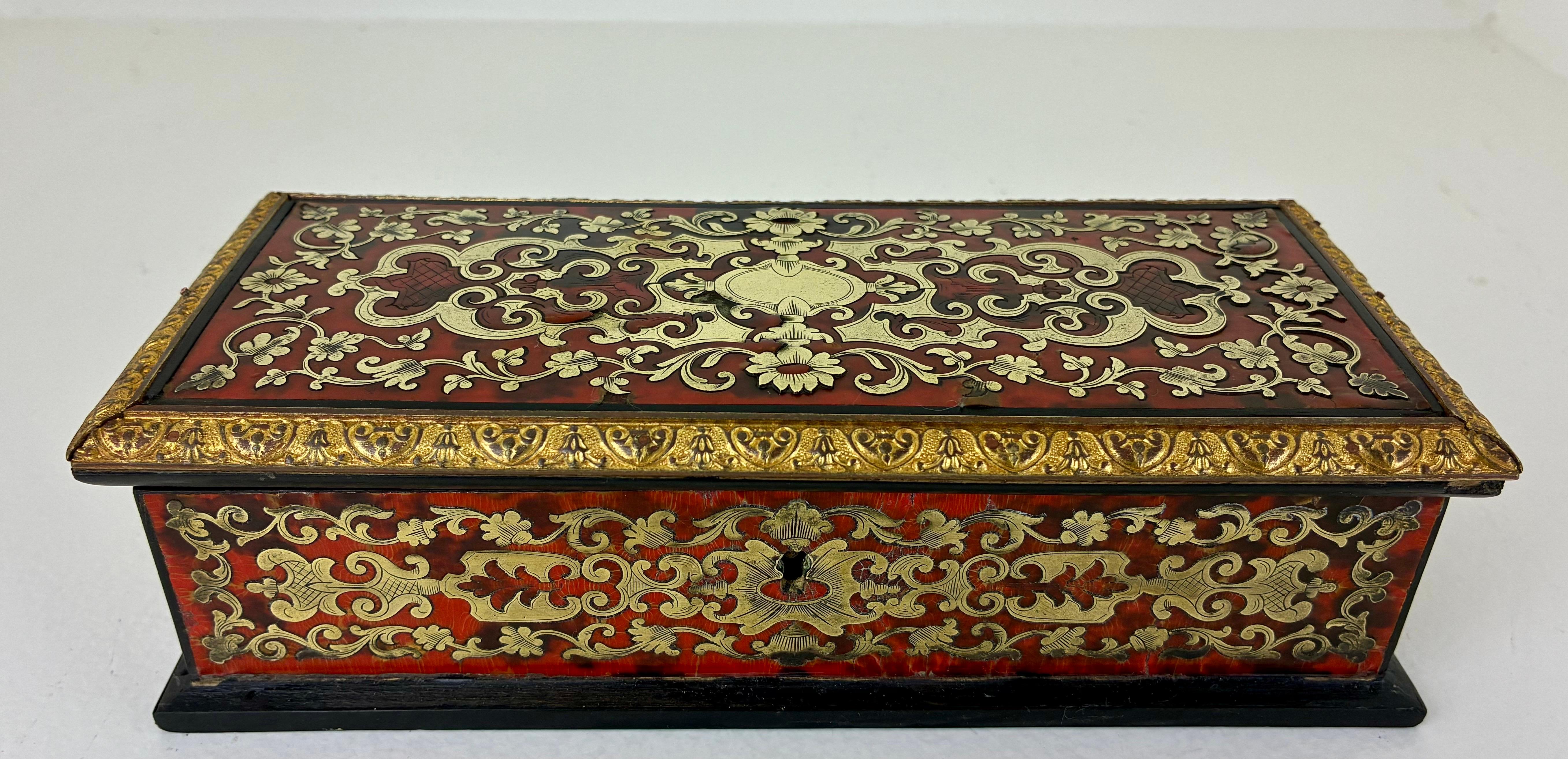 This beautiful inlaid brass and shell Boulle-work lidded box is in very good condition. It retains its original velvet lining and key. 