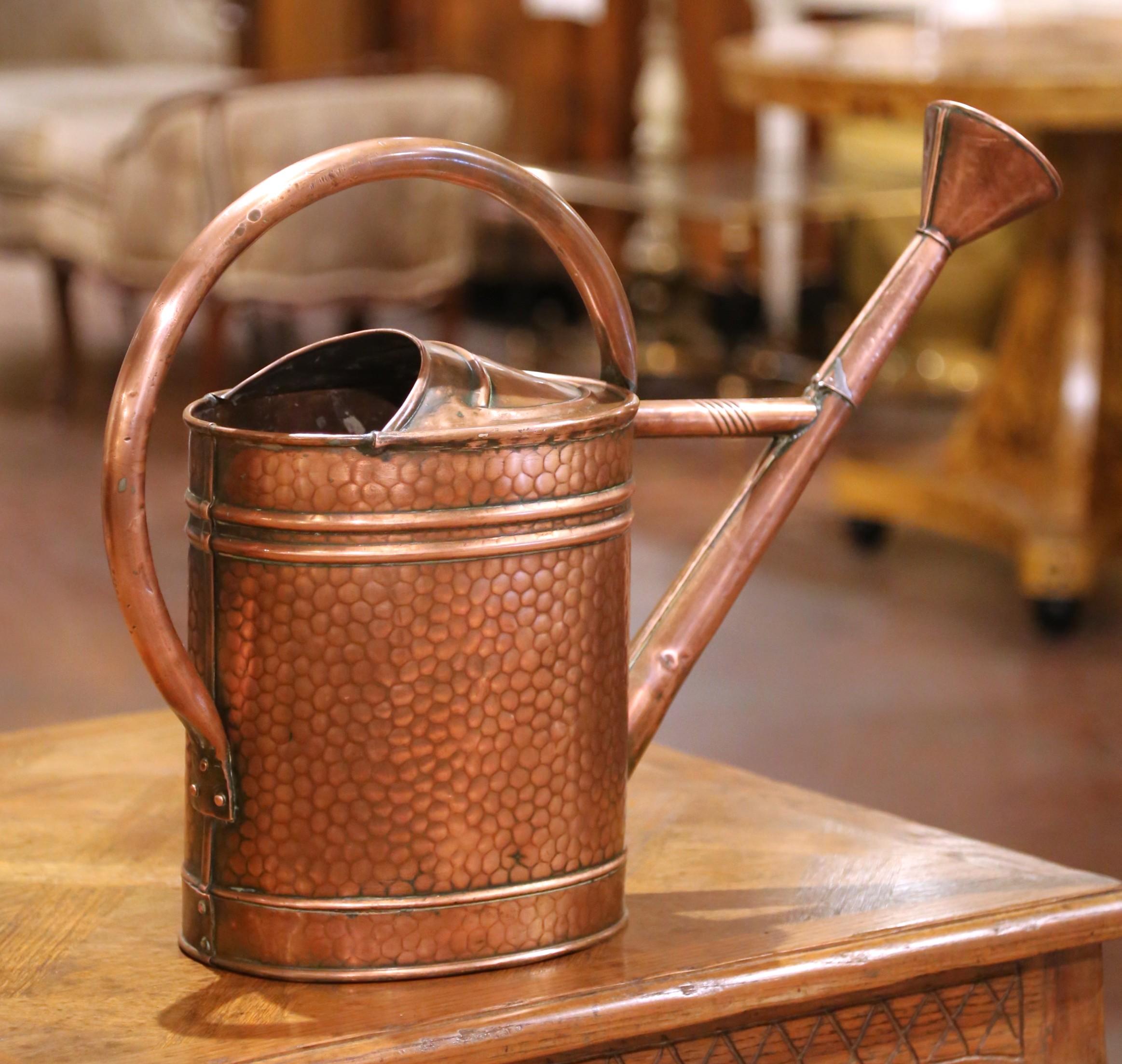 Originaire de Normandie, en France, cet arrosoir du XIXe siècle est un bel exemple de l'artisanat provincial. Le corps cylindrique est fabriqué en cuivre martelé à la main et comporte une poignée en laiton gracieusement arquée et un bec allongé en