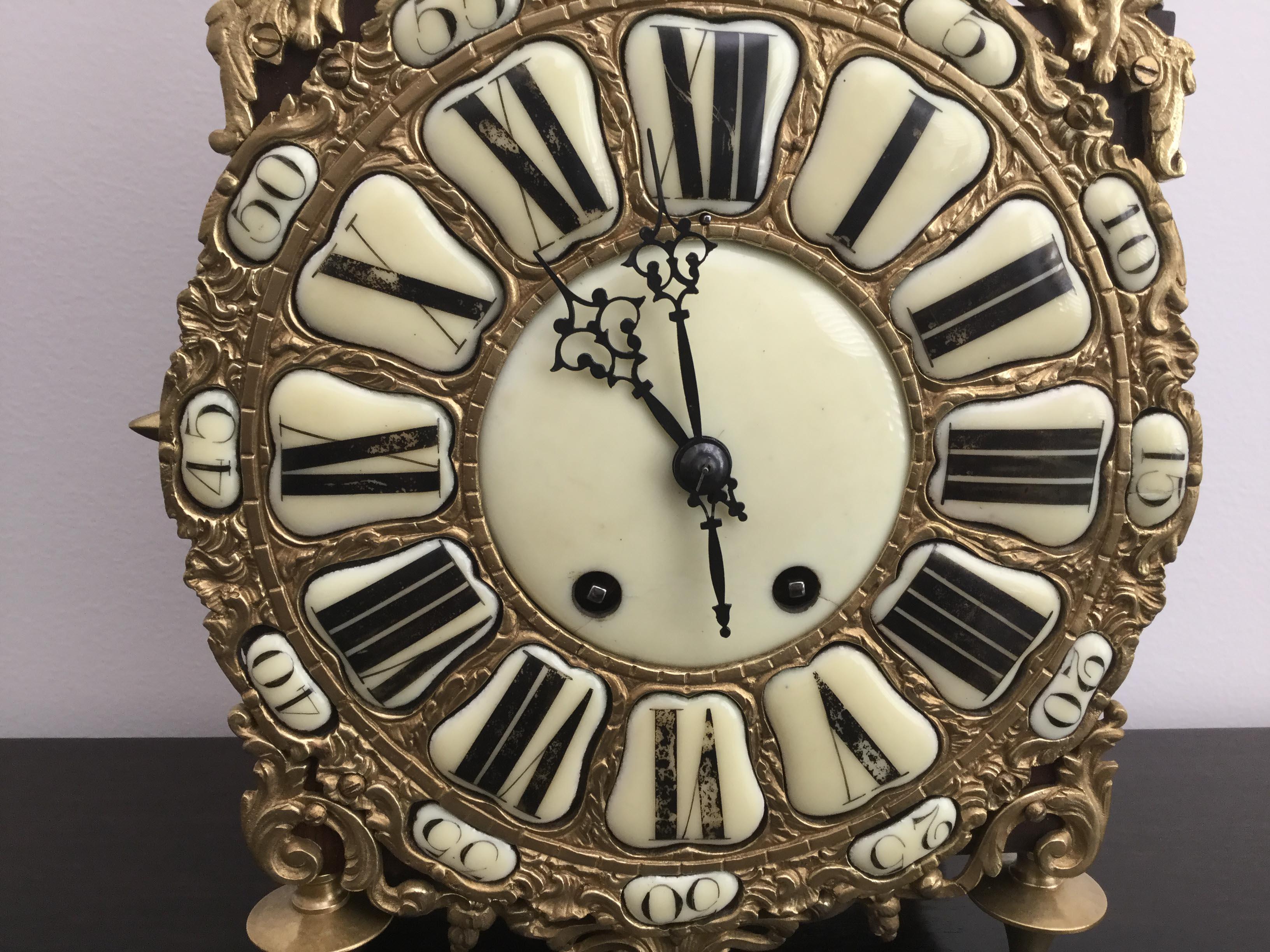 A late 19th century French lantern clock, the dial inset with ceramic numerals showing the hours and minutes. The numerals have some wear which gives the clock a lovely aged appearance.

The brass surround decorated with a female face between four