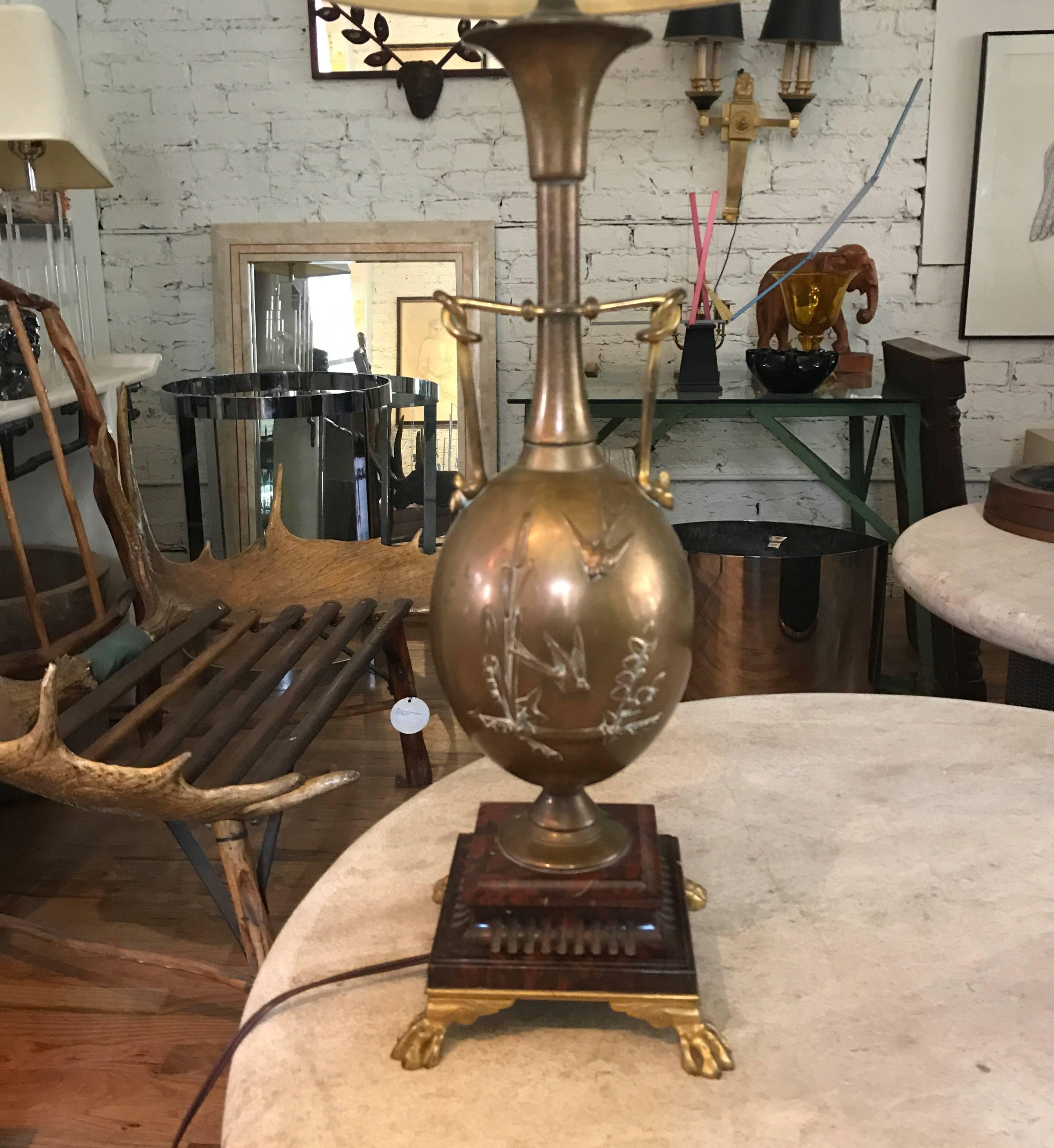 19th century French brass lamp.
The Japonisme lamp was designed by Henry Cahieux and was cast by the distinguished French foundry 
Barbedienne. Its ostrich egg shaped body has Herons cattails and arowwood designs in relief.
The lamps rest on a Rouge