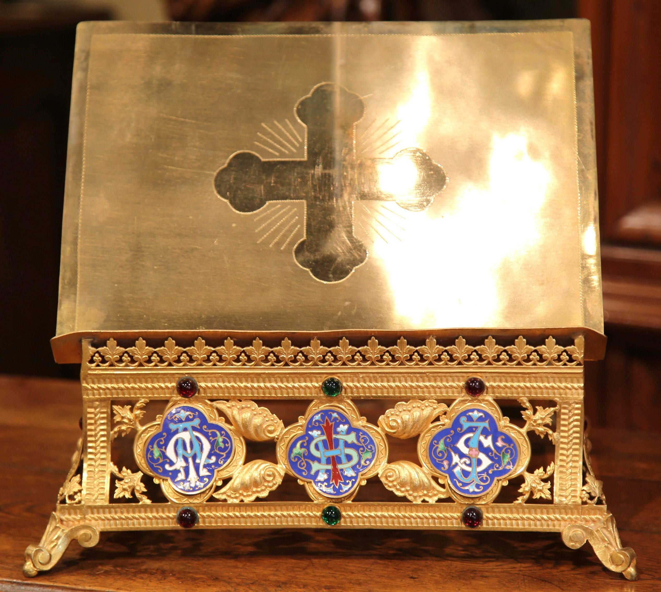 This elegant, antique bible stand was crafted in France, circa 1870. The ornate, adjustable book holder sits on small scroll feet and features a large engraved cross on the front over the adjustable top, with three oval cloisonné rosettes under the