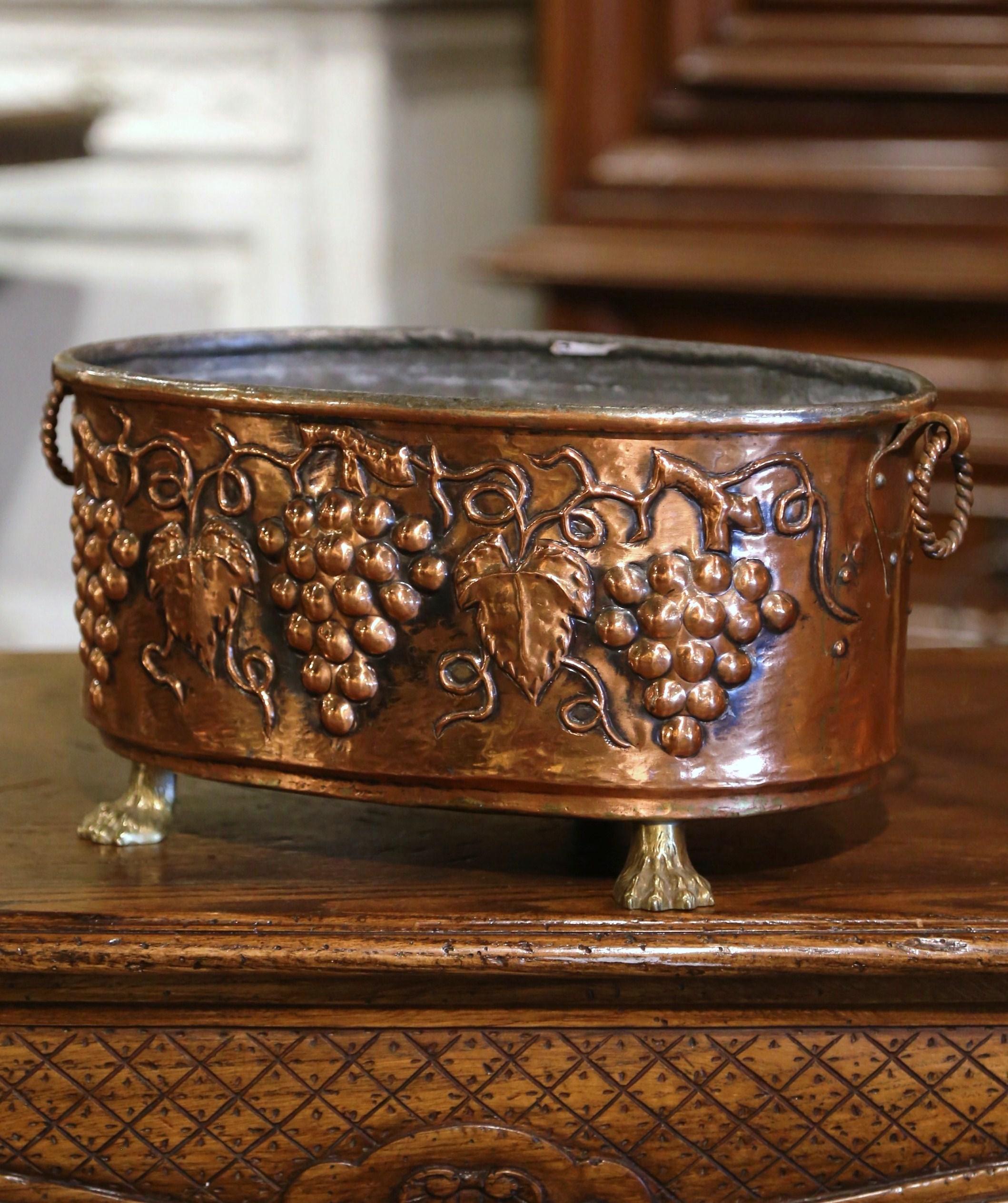 Decorate a wine cellar or wet bar with this elegant antique jardiniere! Crafted in France, circa 1870 and oval in shape, the decorative cache pot stands on small paw feet and features intricate repousse decor of grape, vine and leaf motifs in high