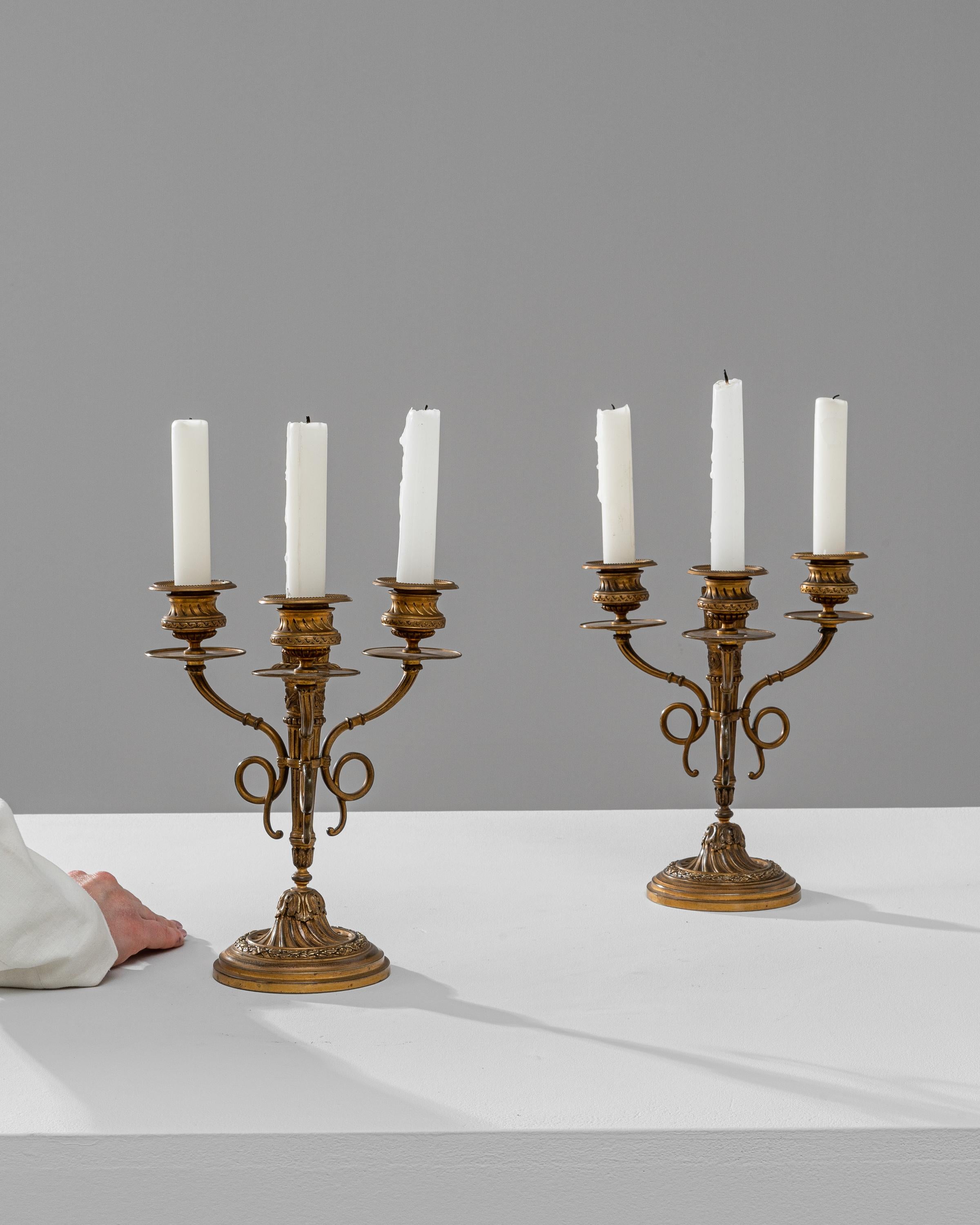 This exquisite pair of 19th Century French Brass Candle Holders is a testament to the opulent design and craftsmanship of the period. Featuring a candelabra design, each holder is meticulously crafted from fine brass, showcasing an ornate base with