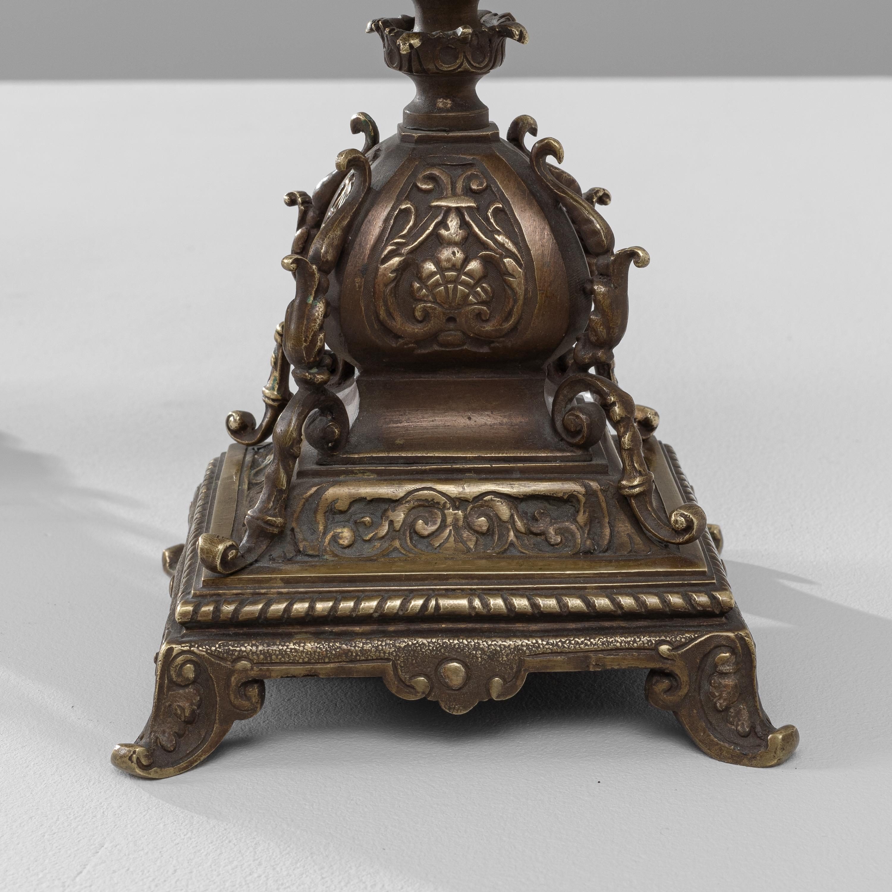 These stately 19th Century French Brass Candle Holders exude a sense of regal sophistication with their elaborate and ornate design. Each candelabra stands on a detailed square base, adorned with classical motifs that include acanthus leaves,