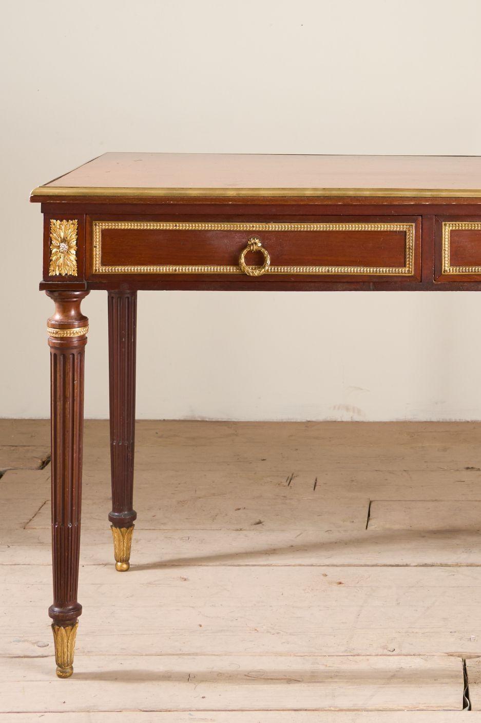 Il s'agit d'une table à écrire française en acajou massif de très haute qualité datant du 19e siècle. Le plateau est constitué d'une seule pièce d'acajou et de bords en laiton, ce qui lui confère un design saisissant. Les pieds sont élégamment