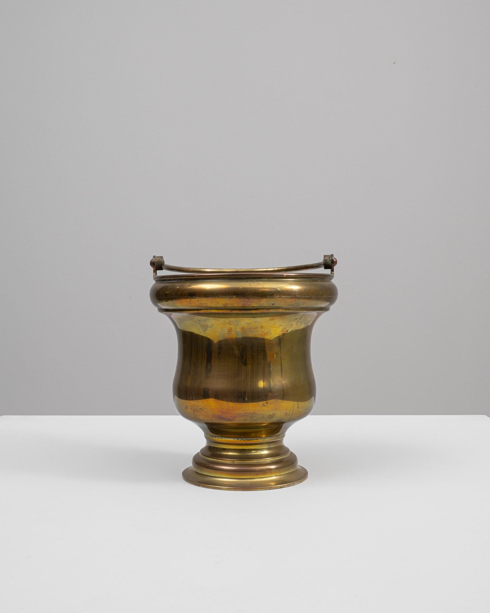 This 19th-century French brass ice bucket is a piece that exudes vintage charm and elegance. Its gleaming brass construction features a subtle patina that tells the tale of numerous festive gatherings and soirees. The bucket is shaped with a