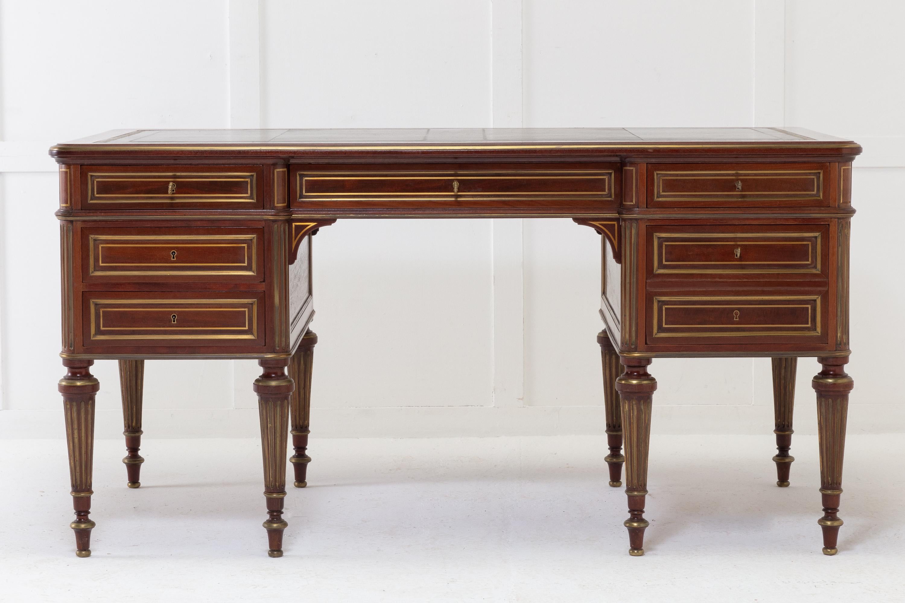 Fine 19th century French brass inlaid mahogany desk of exceptional quality. Having old tooled leather and brass moulding to the top and with seven brass inlaid and moulded drawers. The sides are also brass inlaid and brass moulded. Having two pull