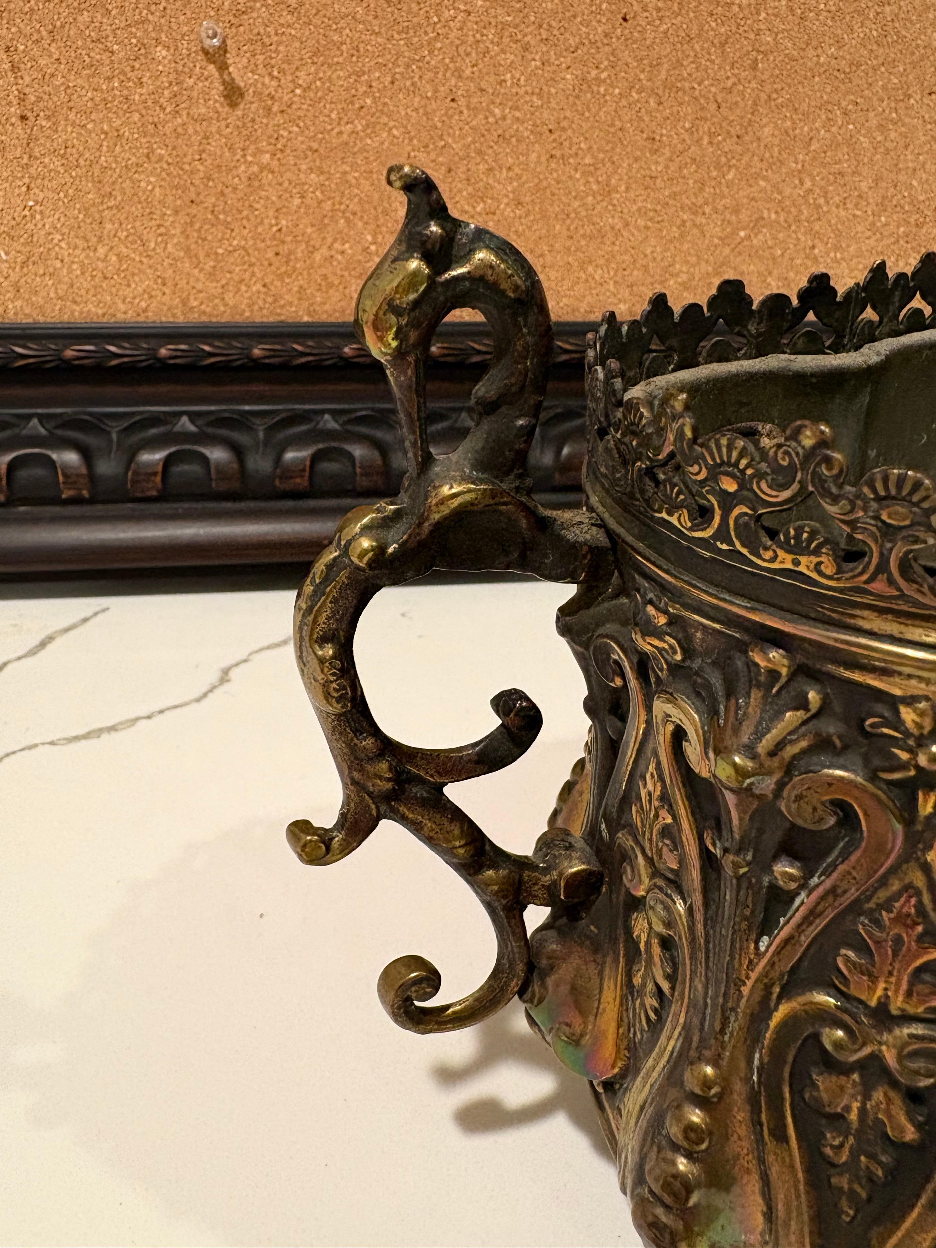 This French Art Nouveau brass jardiniere/planter with original tin liner, has been repolished and is flanked by twin swan handles. The oval shaped body of the jardiniere features Repousse' with chasing work. The insert has small handles for easy