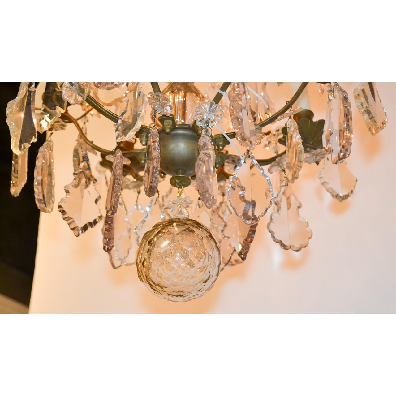 Beautiful 19th century French bronze and cut crystal chandelier. The crown decorated with rosettes and star flowers above a shaped stem with four scrolling arms with scalloped bobeche. Richly adorned overall with pendeloque and kite-shaped crystal