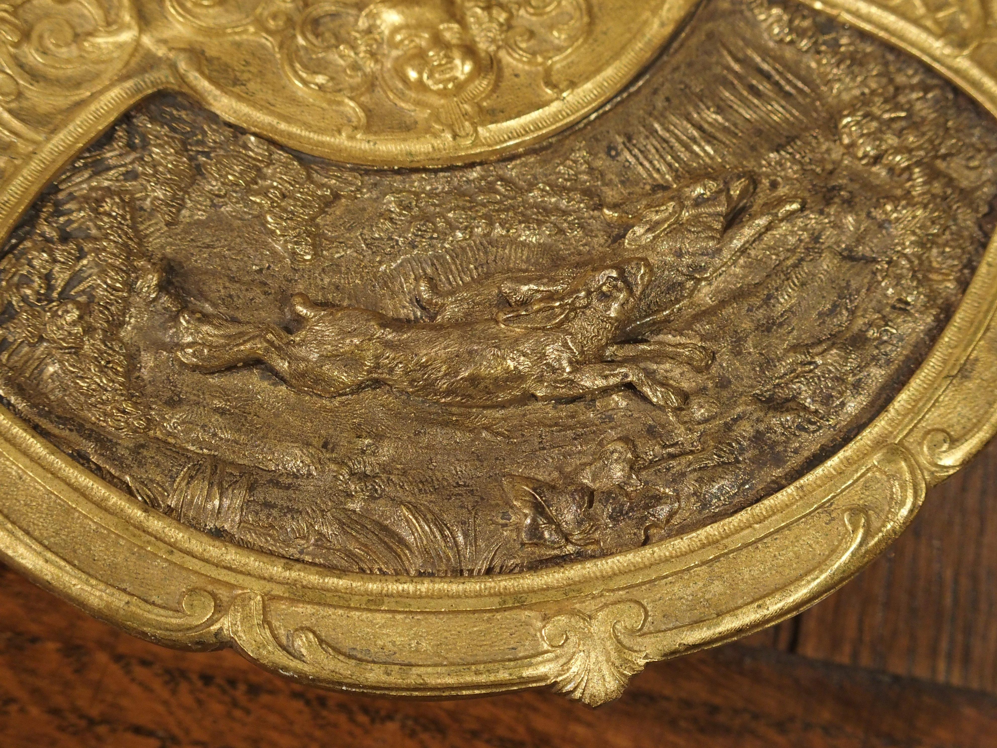 This multi-faceted antique crystal inkwell on gilt bronze platter is highly decorated with animals and birds throughout. The top flips open and is crowned with a deer. It opens to a gilt lined rim on a beautiful geometric crystal inkwell. This sets
