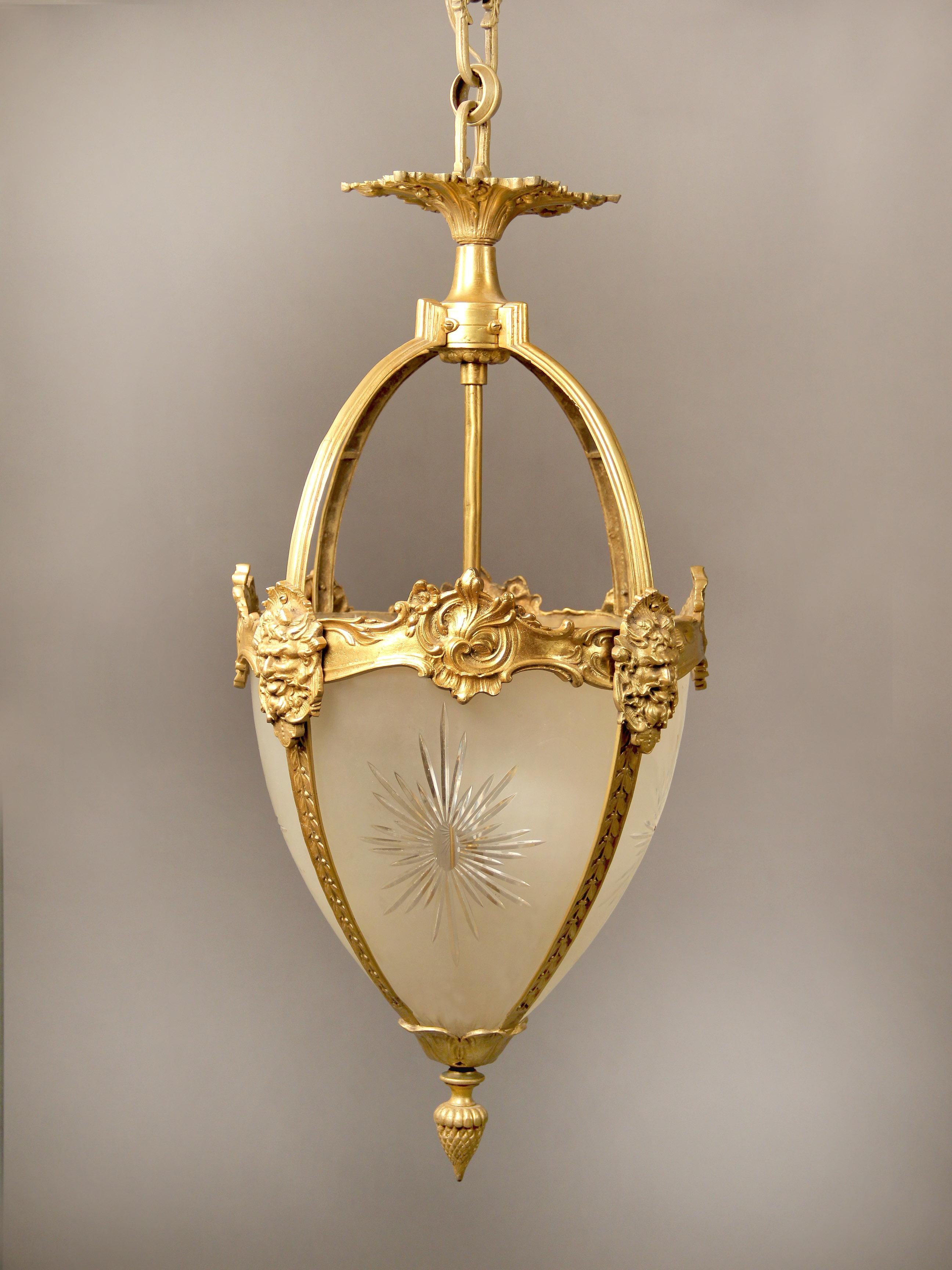 Lanterne de salle en bronze français et verre dépoli gravé de la fin du 19e siècle/début du 20e siècle

De forme ovoïde, avec quatre panneaux de verre gravé en forme de soleil, des masques de Bacchus montés en bronze menant à un fleuron en forme de