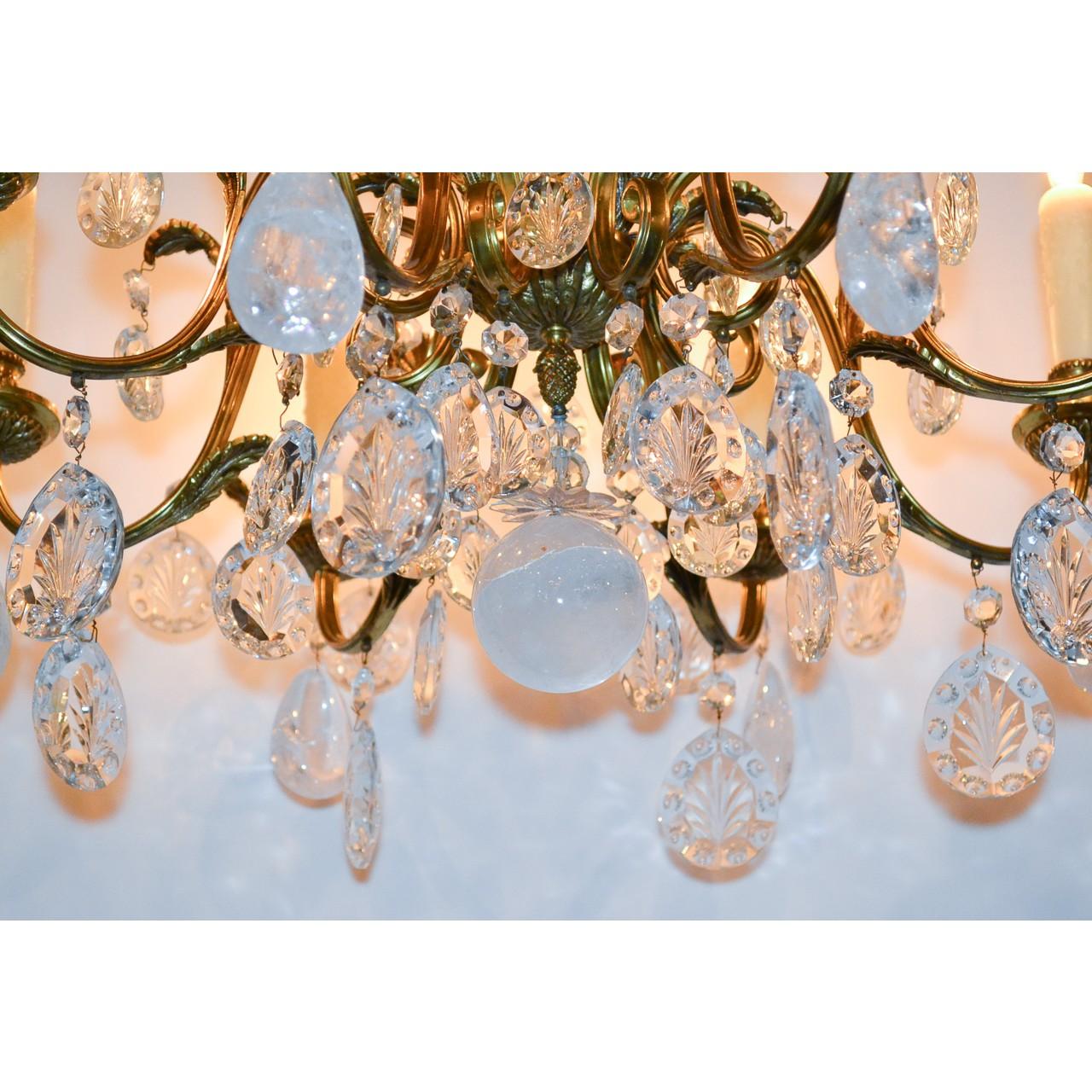 Exquisite early 20th century French gold-gilded bronze chandelier with superb contrasting cut crystals and polished rock crystal. The leaf spray crown adorned with cut and faceted crystal prisms atop a ribbed and fluted shaped stem. Mounted with