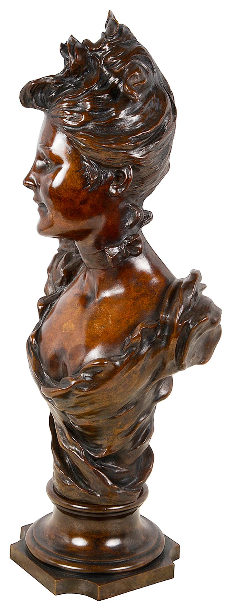 A good quality 19th Century French Bronze patinated bust of a young lady wearing a flower in her hair, a classical dress and raised on a sockel base.